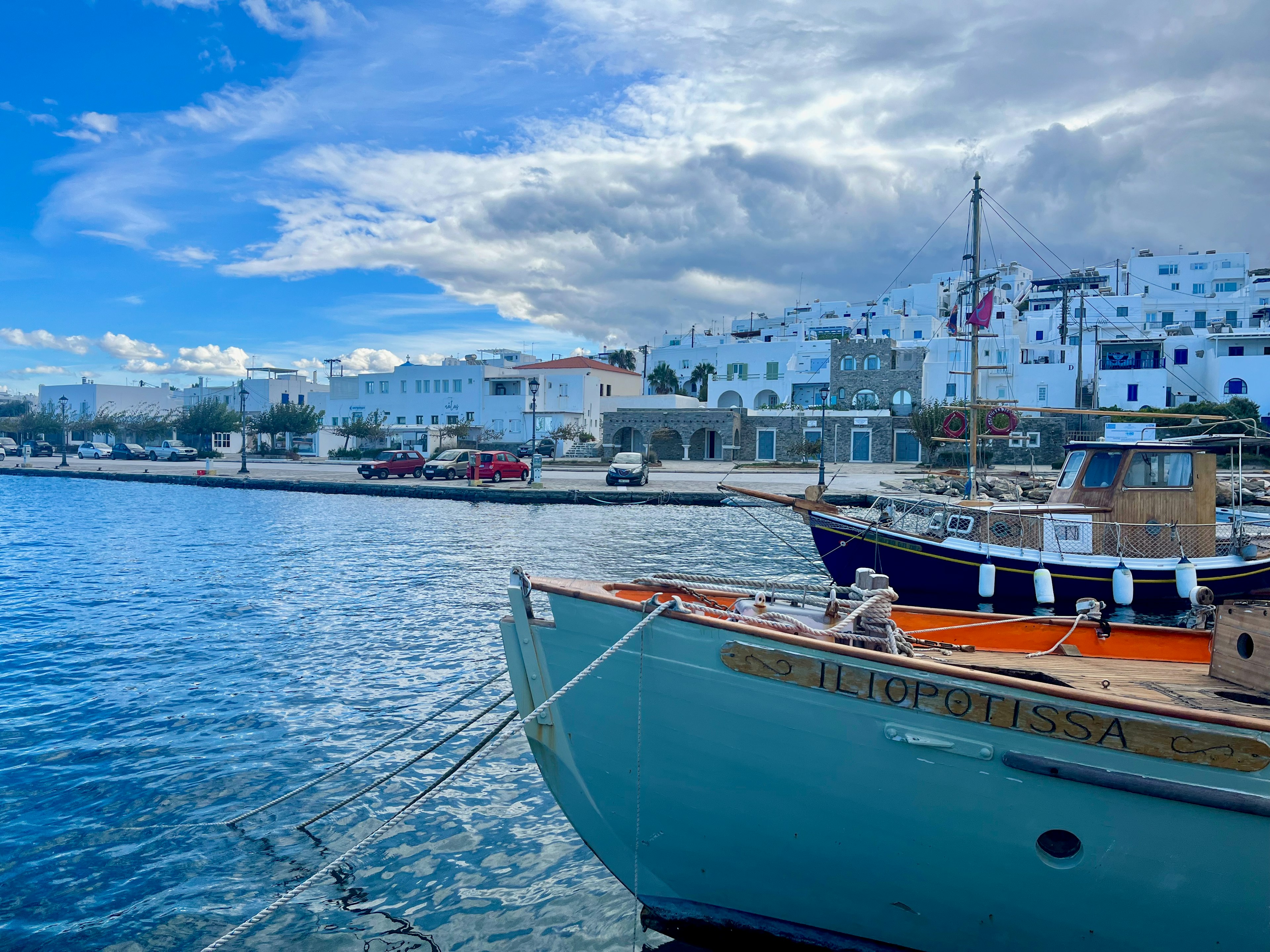 Un bateau amarré dans un port avec de l'eau bleue et des bâtiments blancs