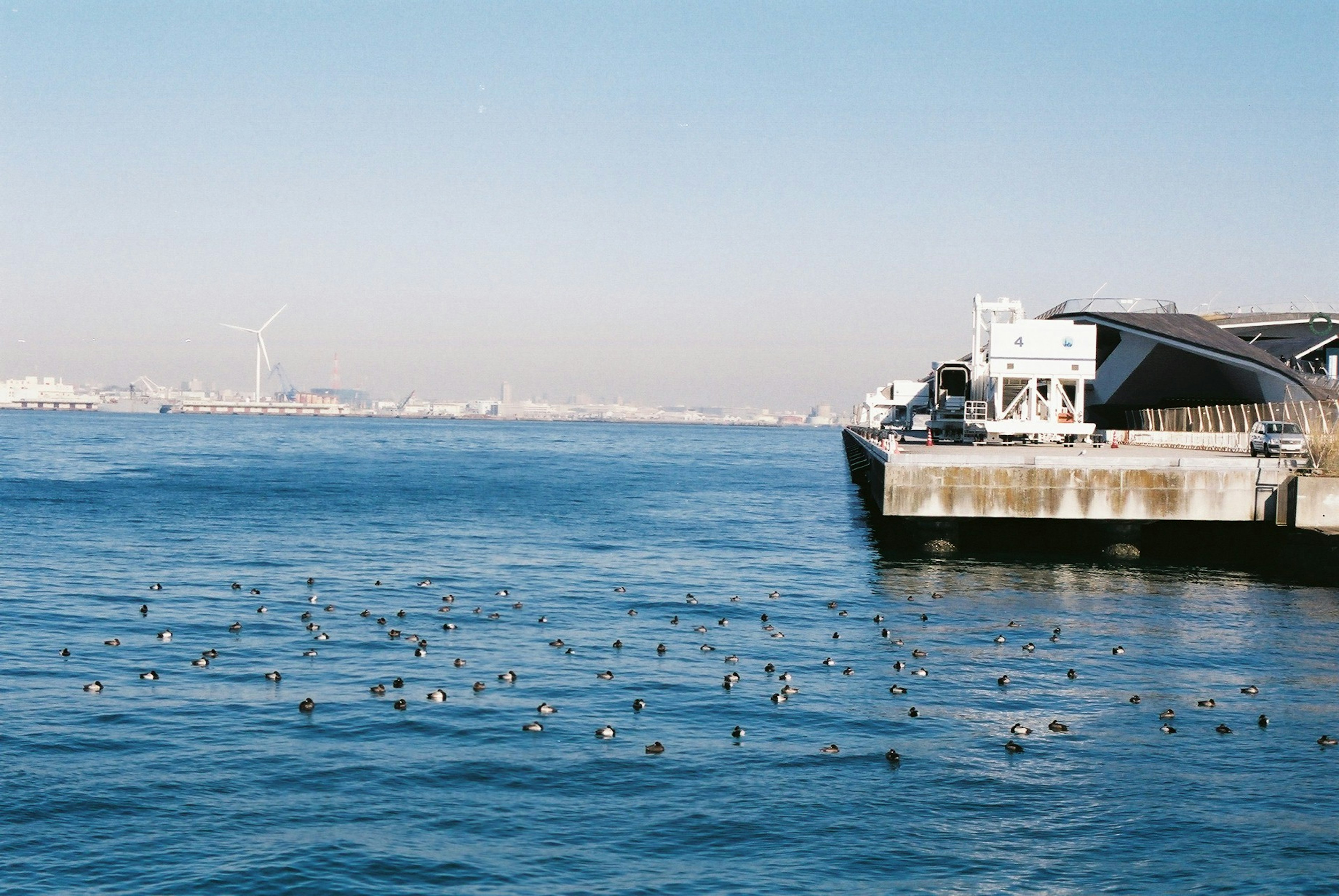 Vista escénica del océano azul con un muelle y un horizonte lejano