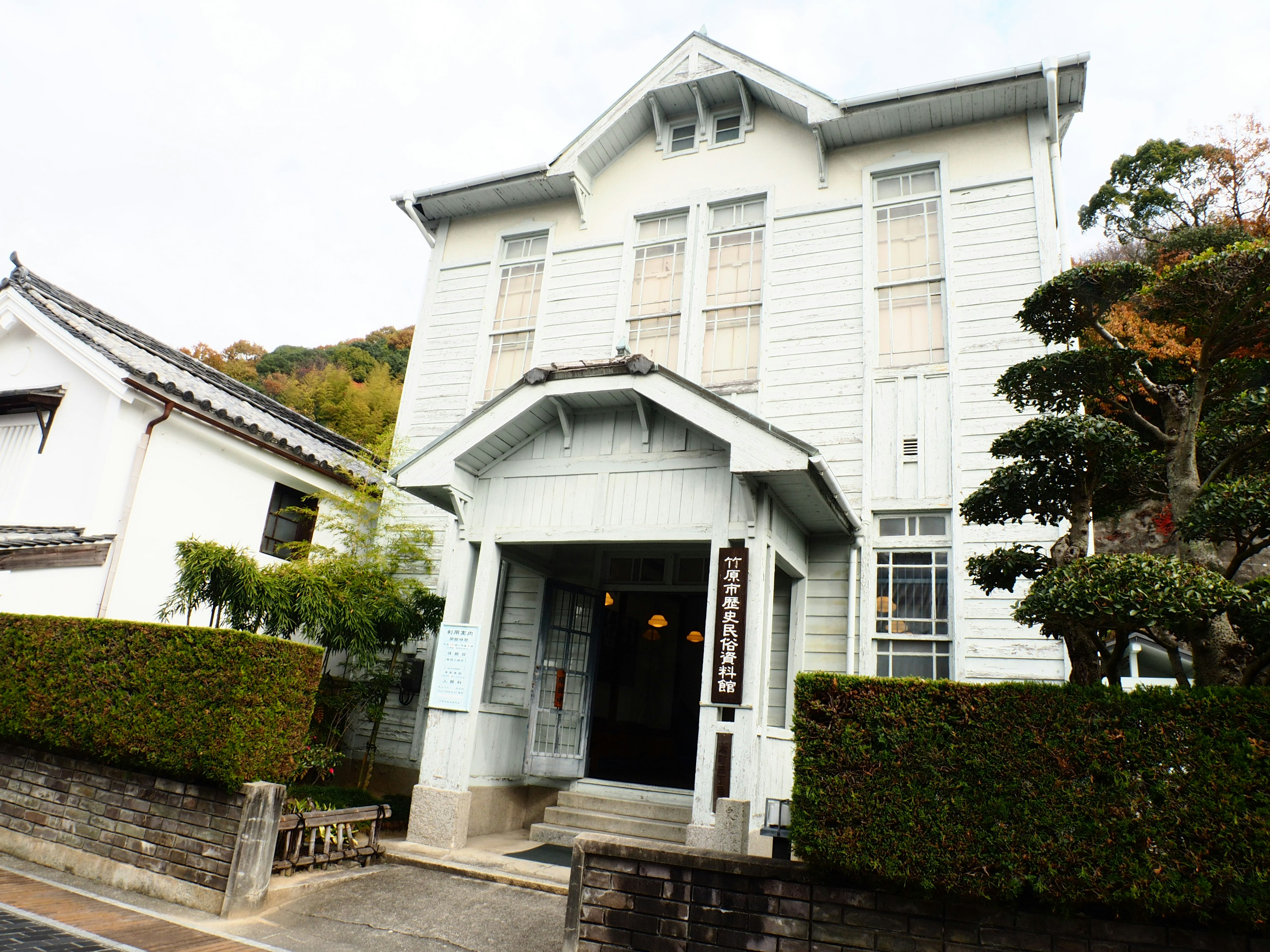 Traditional building with white exterior and lush green landscaping