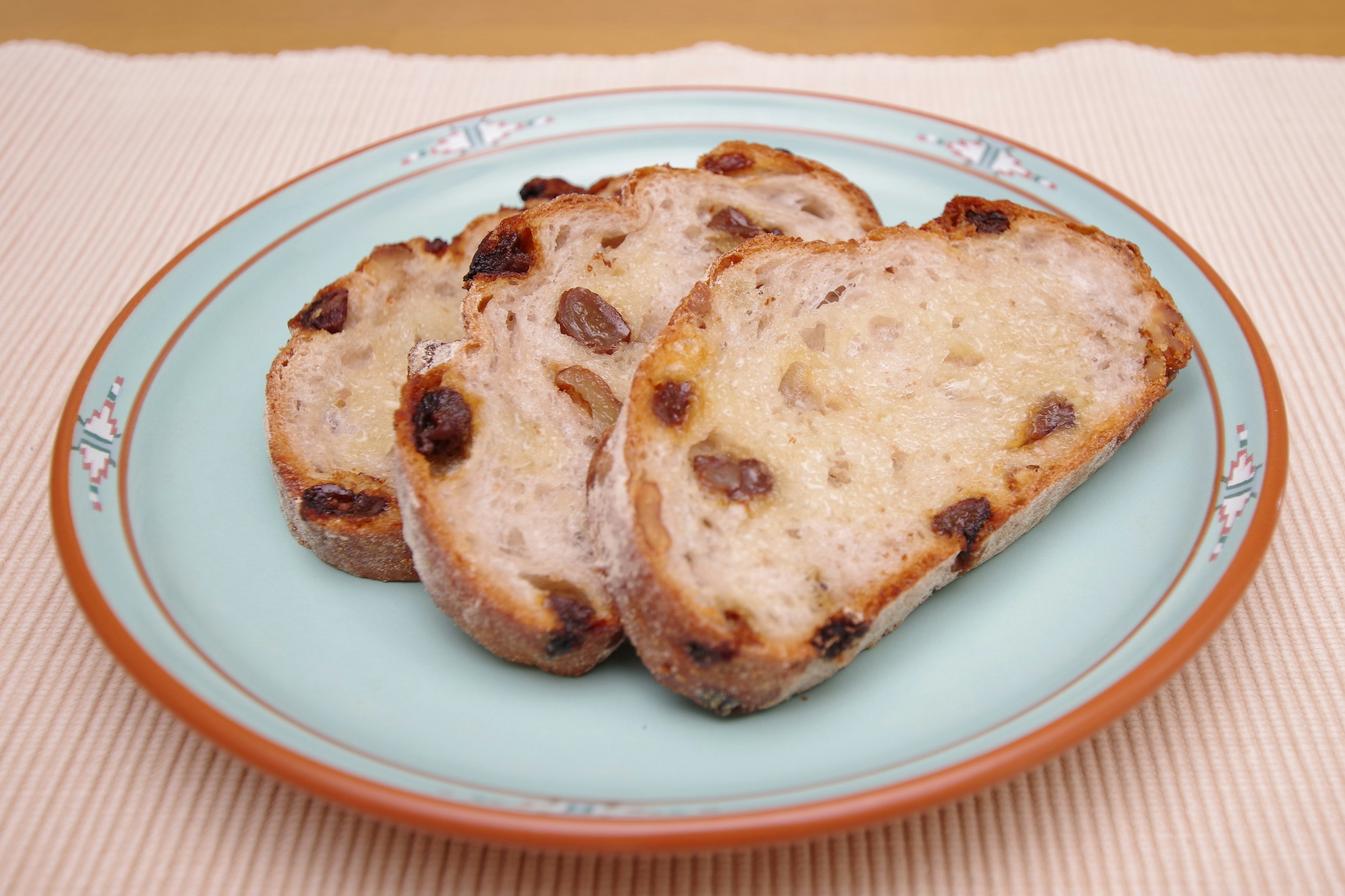 Pan de pasas en rodajas presentado en un plato azul