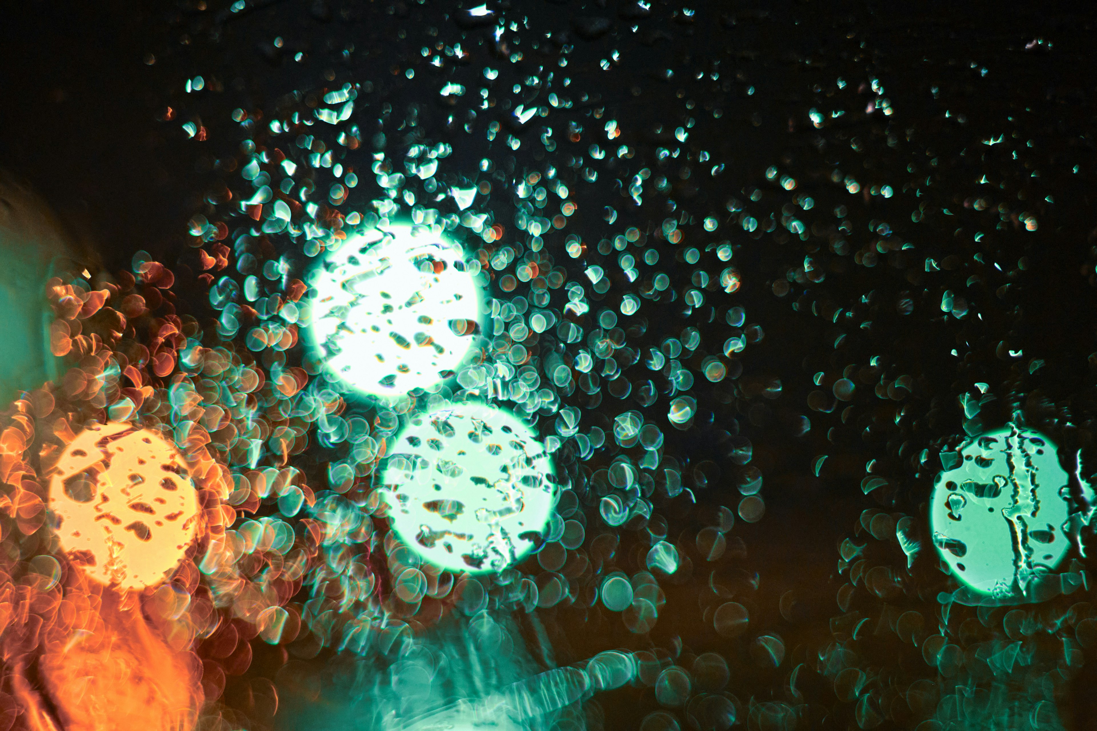 Sphères de lumière floues avec des gouttes de pluie et des reflets colorés