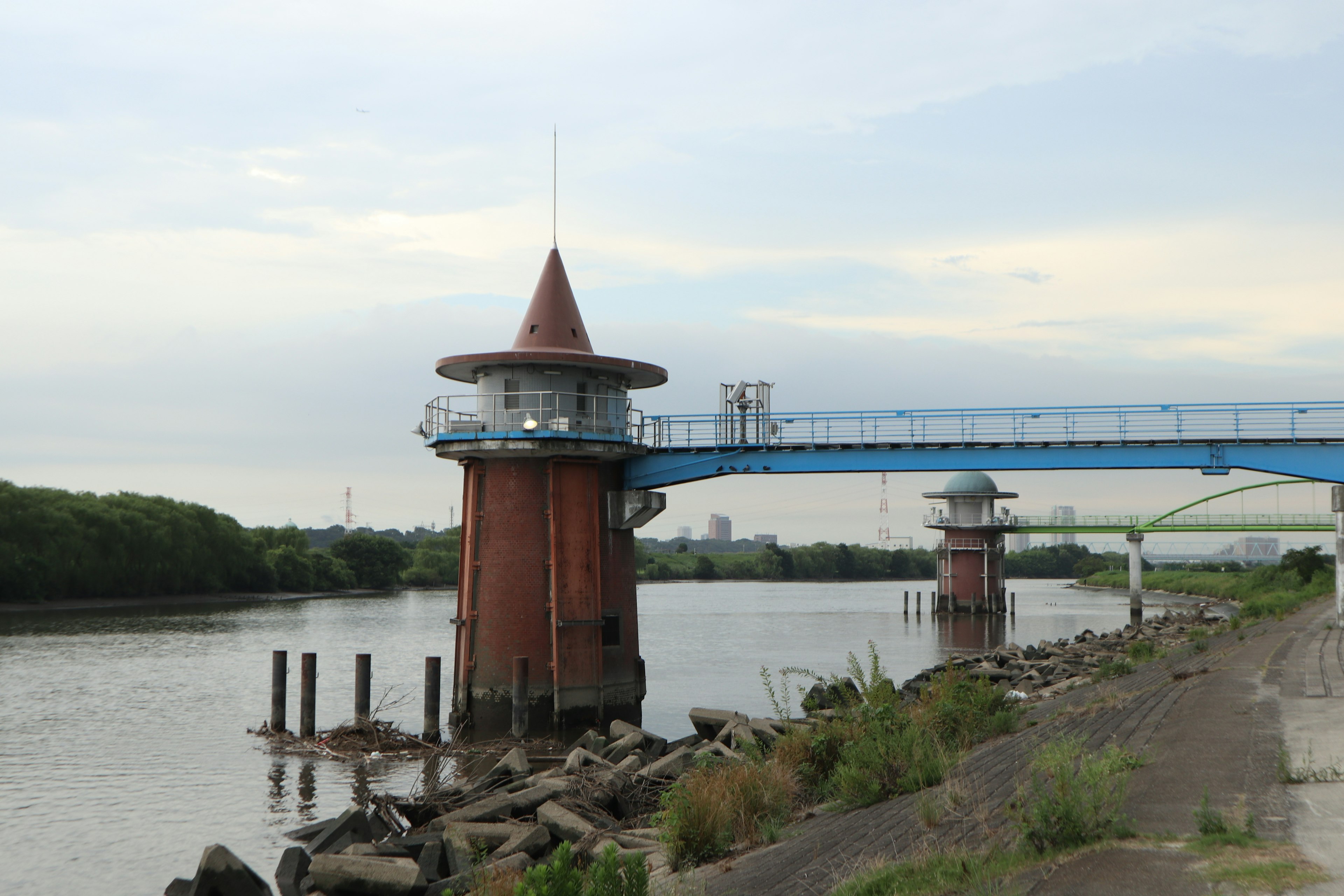 Pemandangan dengan menara merah dan jembatan biru di tepi sungai