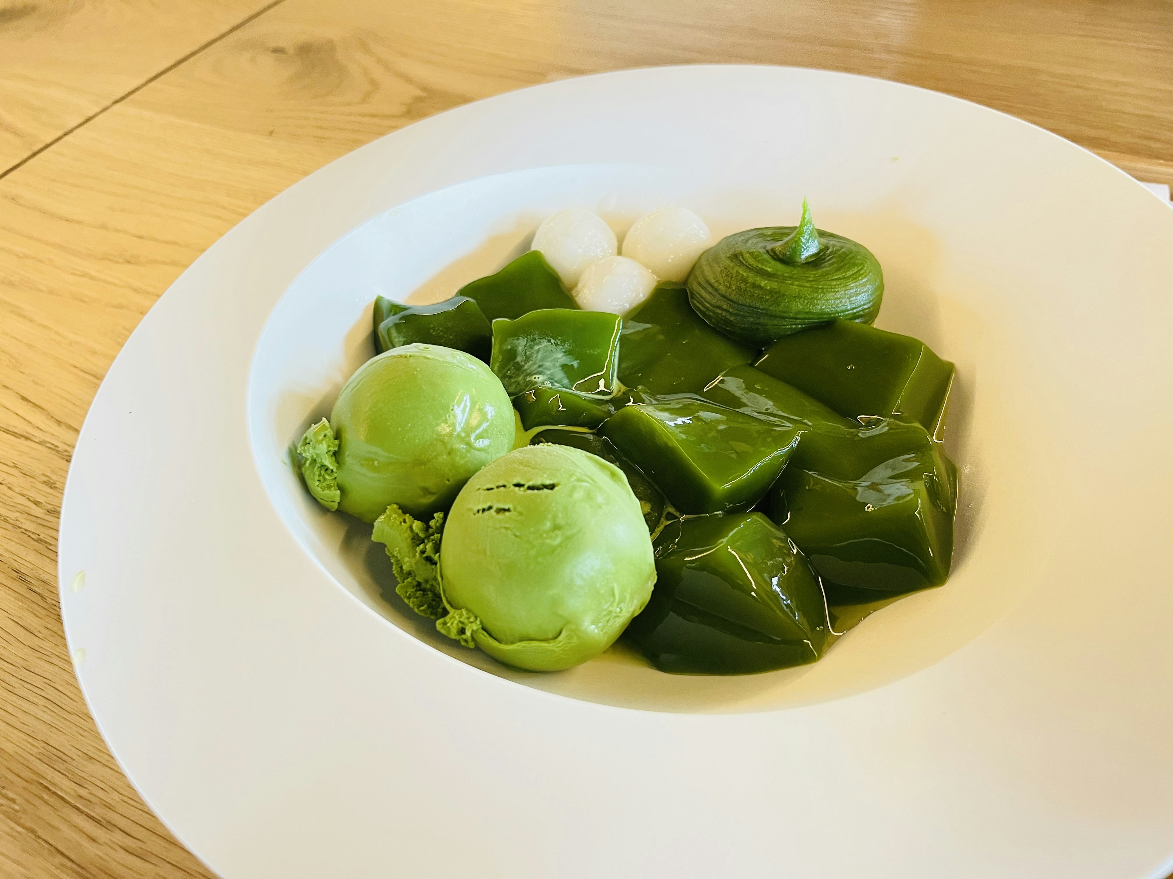 A plate with various green ingredients arranged artistically