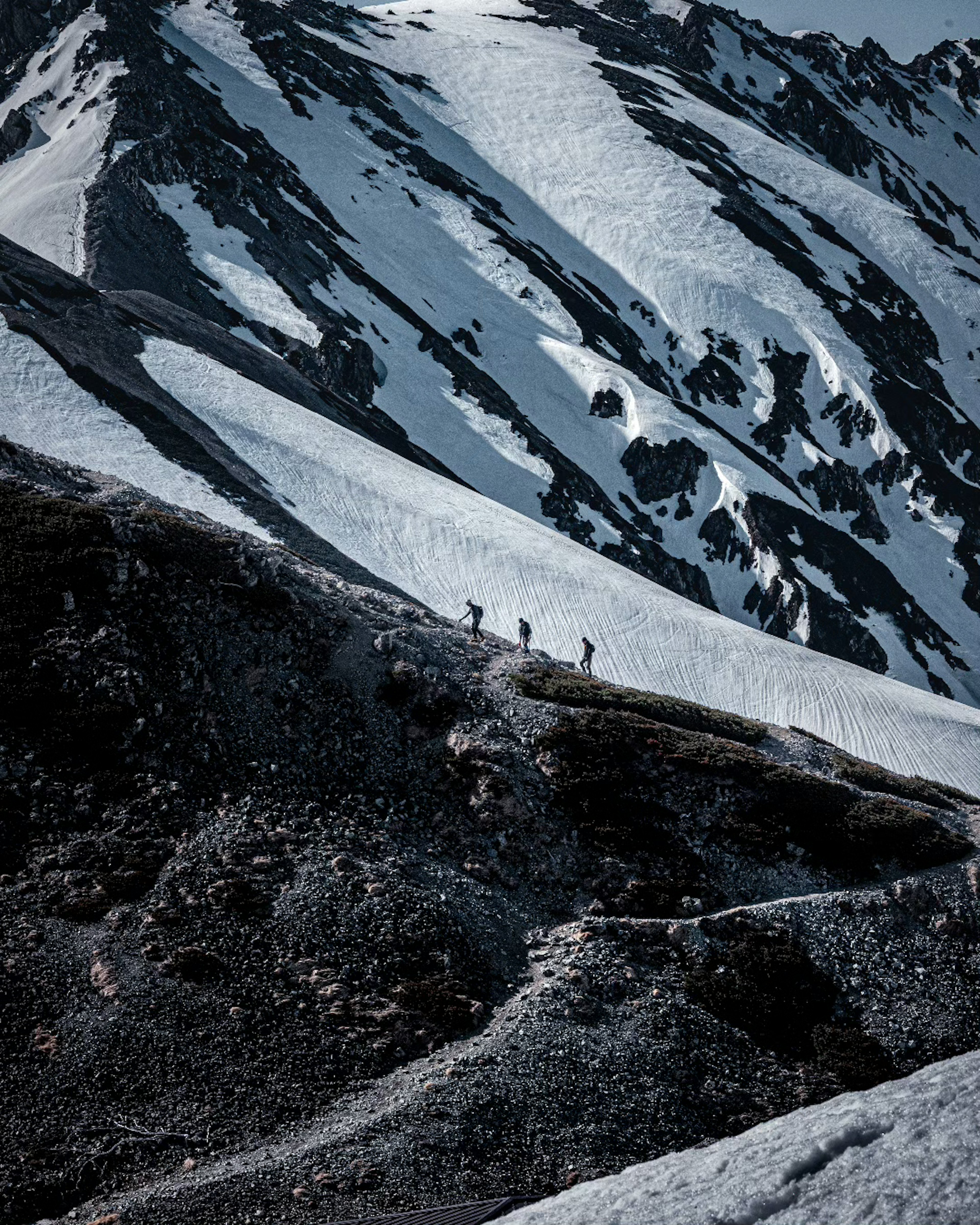 Siluetas de escaladores en un paisaje montañoso nevado