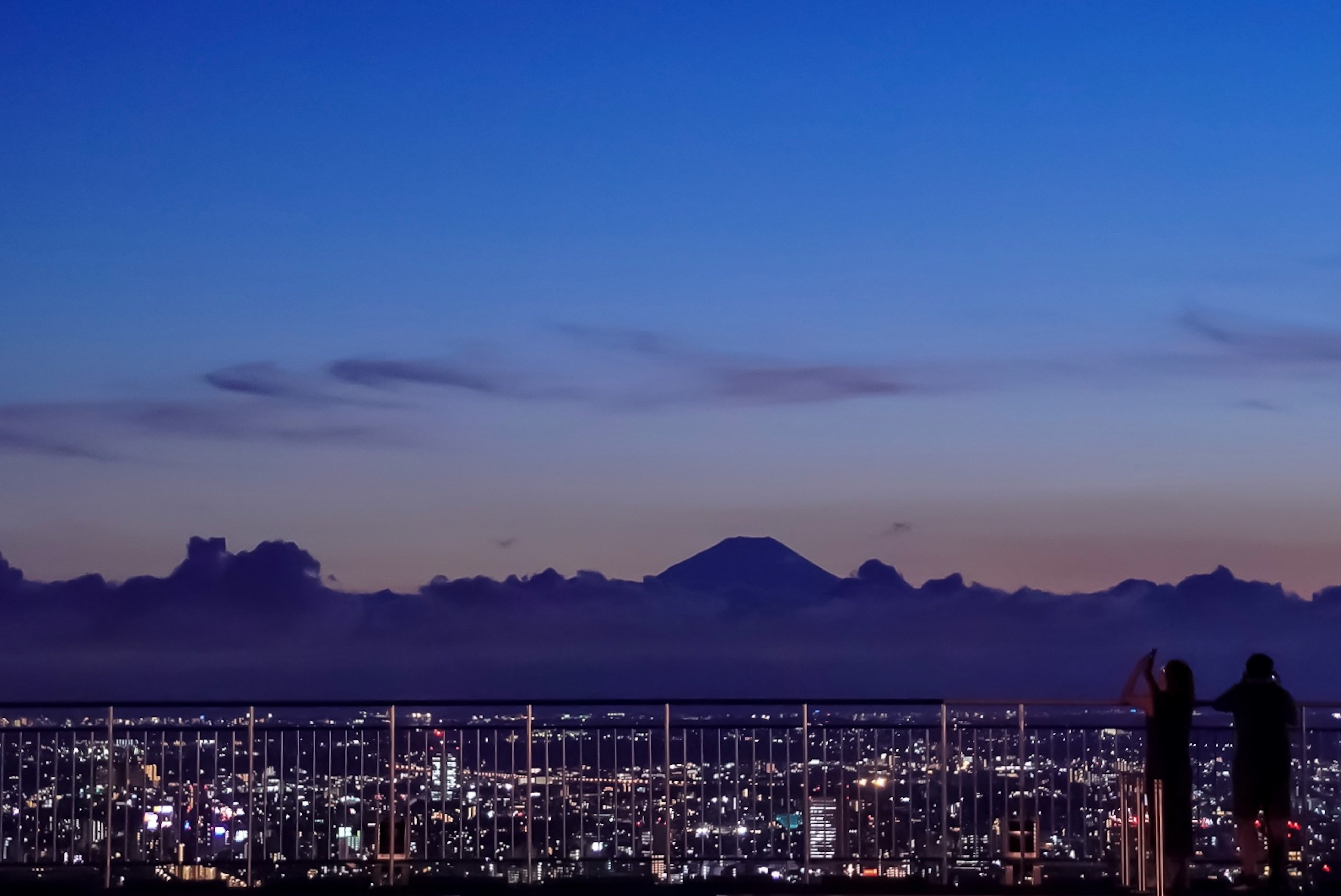 夜景の東京と富士山を背景にしたカップル