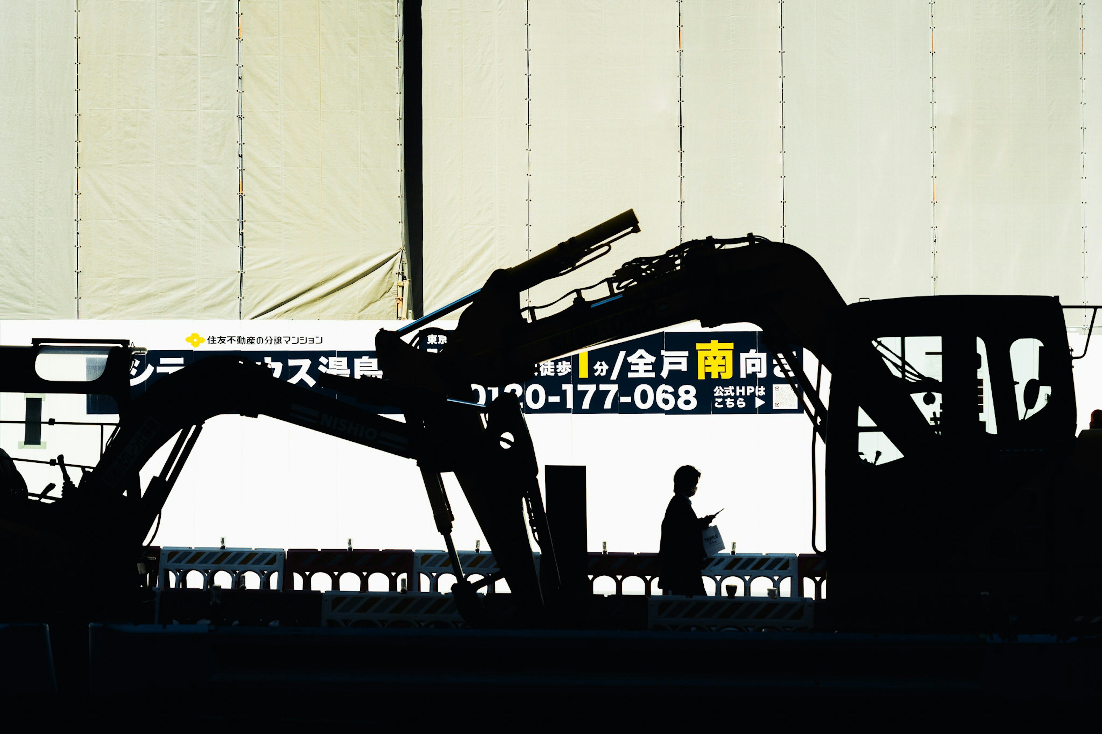 Silhouette di macchine edili e di un lavoratore in un cantiere