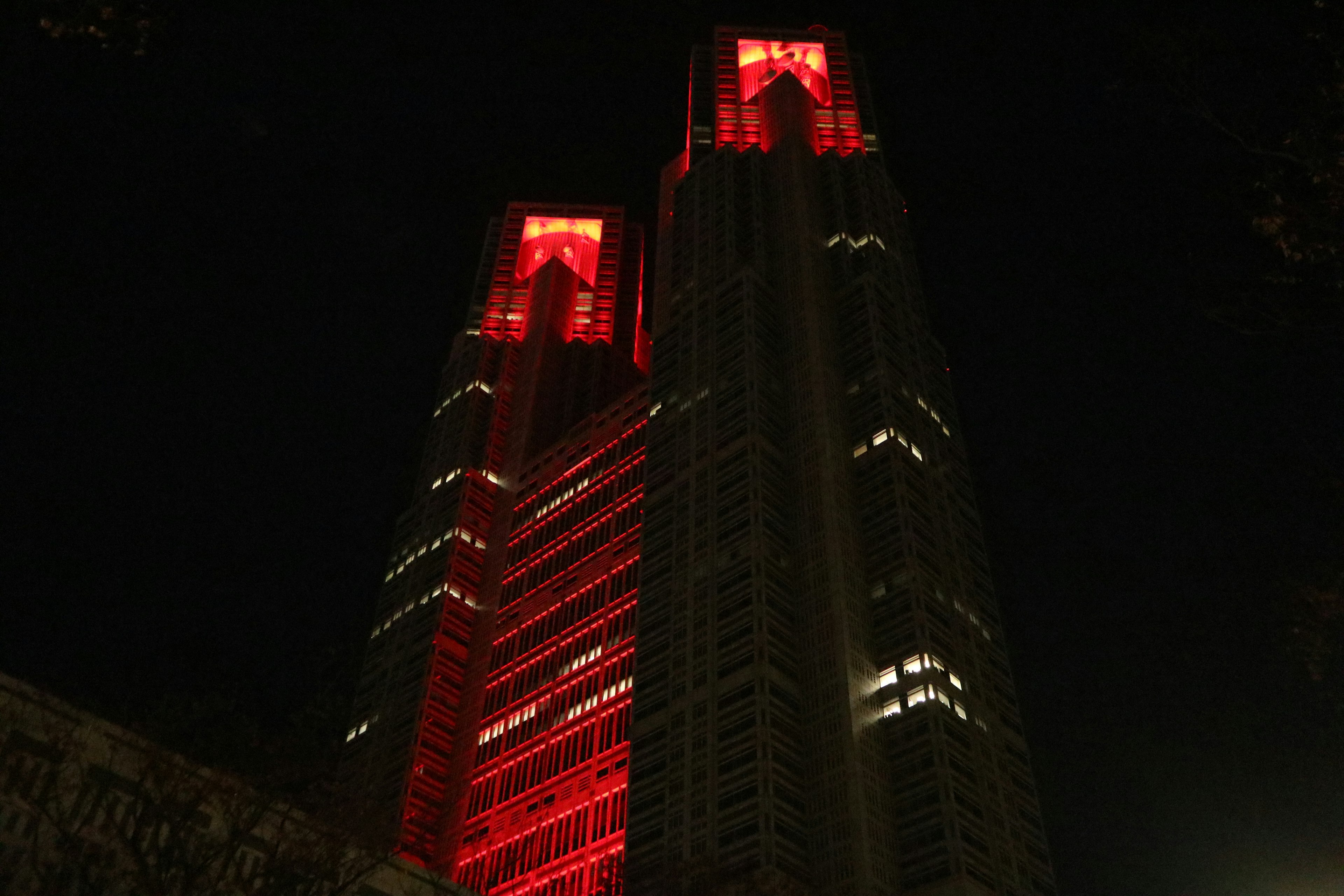 夜の東京で赤くライトアップされた二つの高層ビル