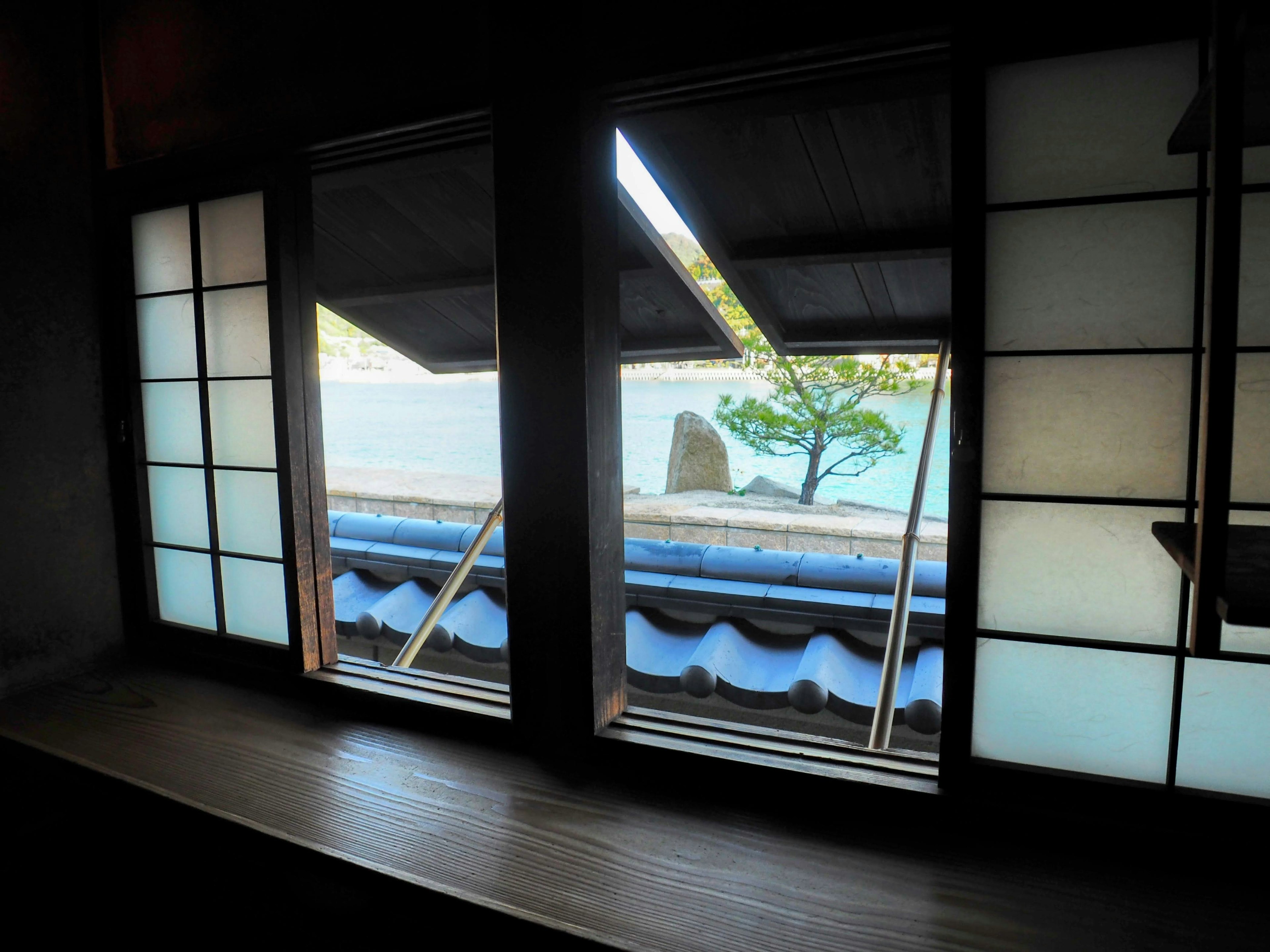 View through traditional windows showcasing blue roof and serene sea