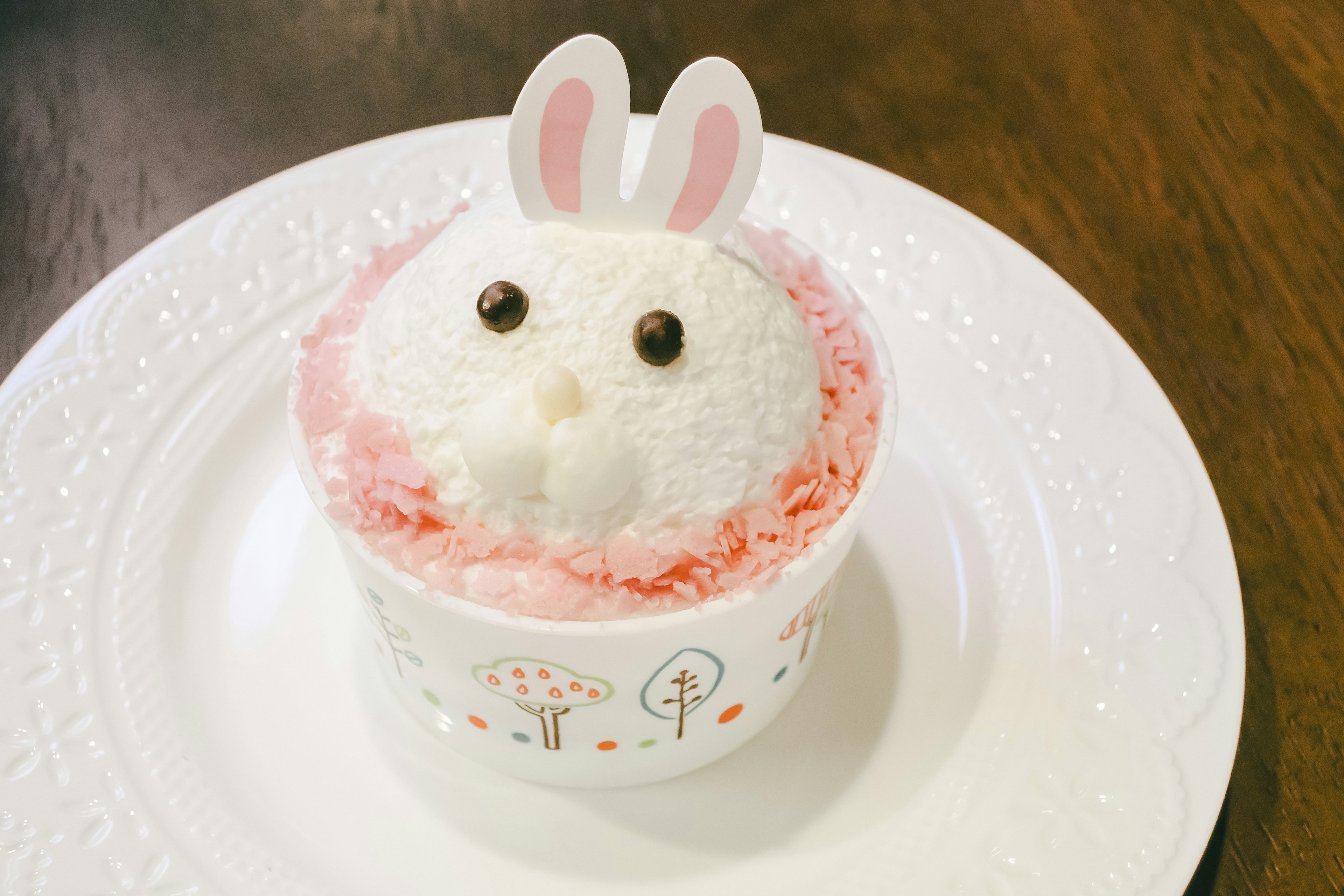 A cute dessert shaped like a rabbit decorated with pink cream