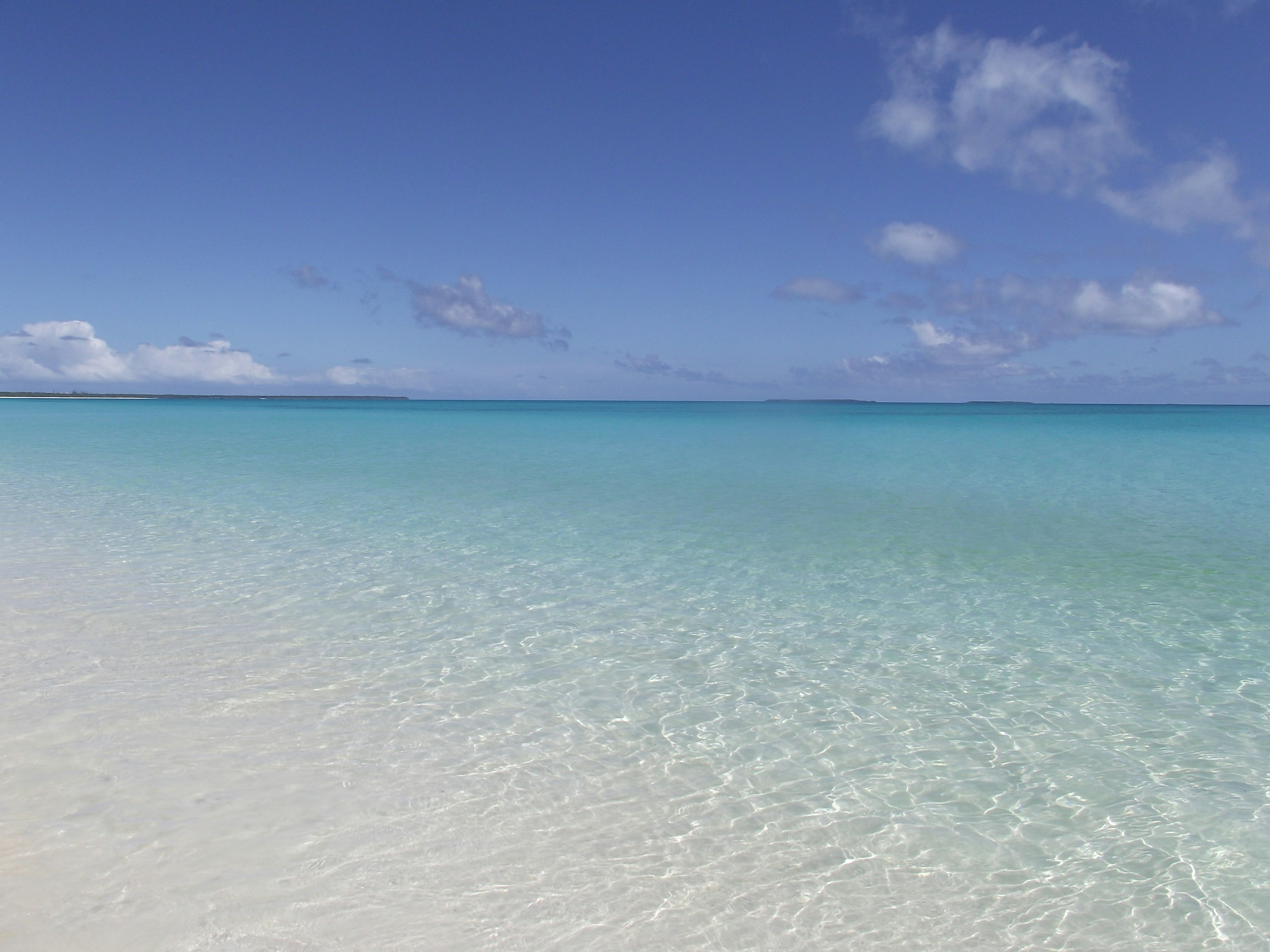 Pemandangan laut turquoise jernih di bawah langit biru