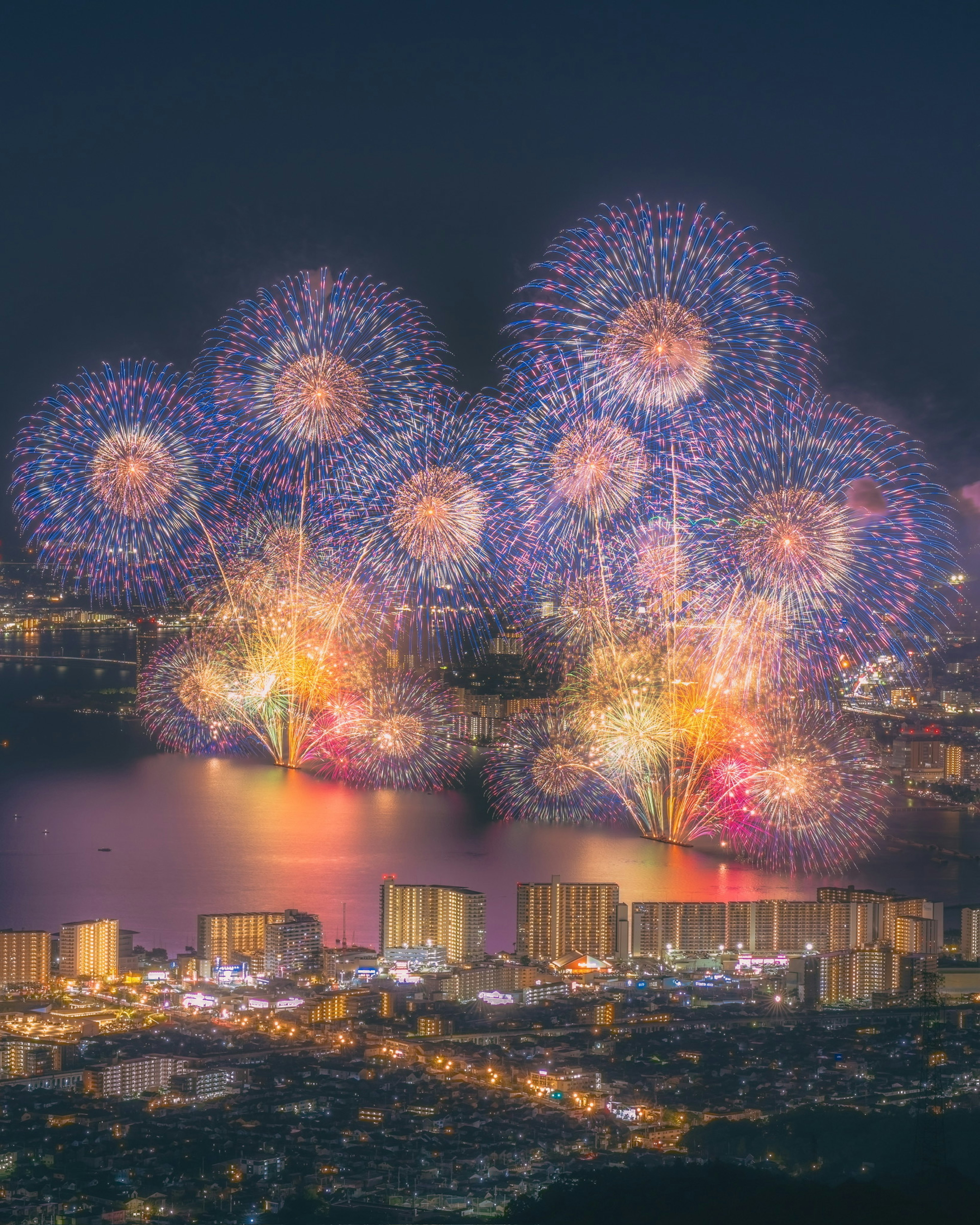 Fuegos artificiales coloridos estallando sobre el horizonte de una ciudad por la noche