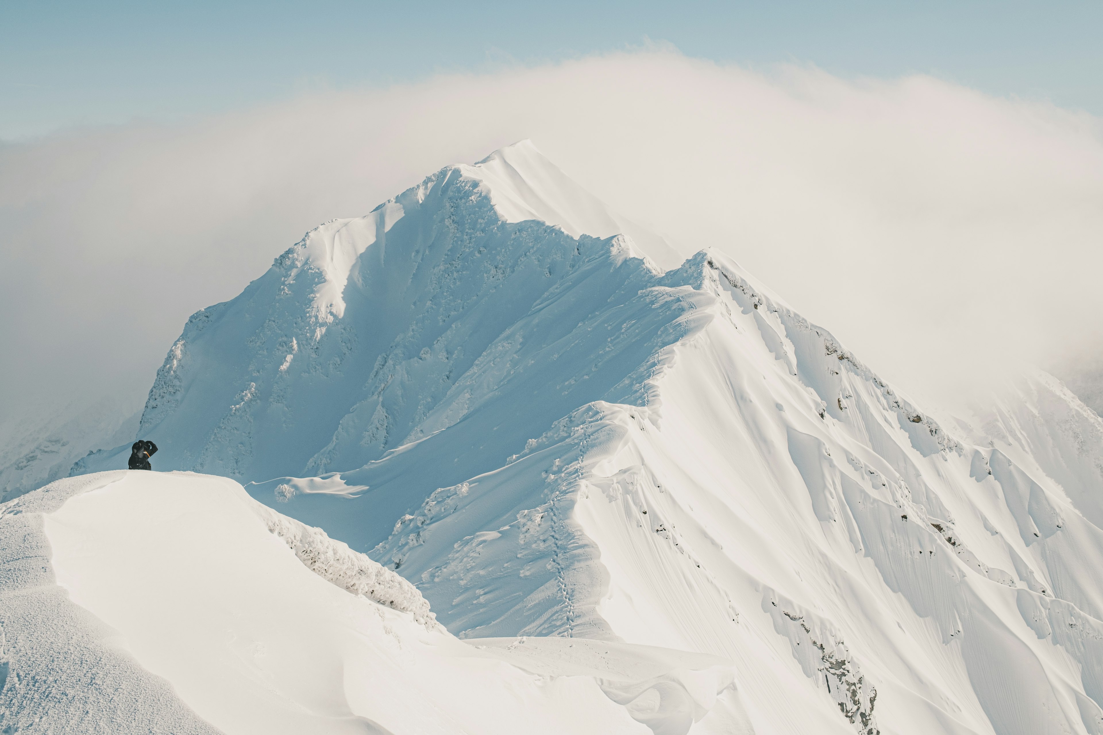 Snow-covered mountain peak with clouds in the background