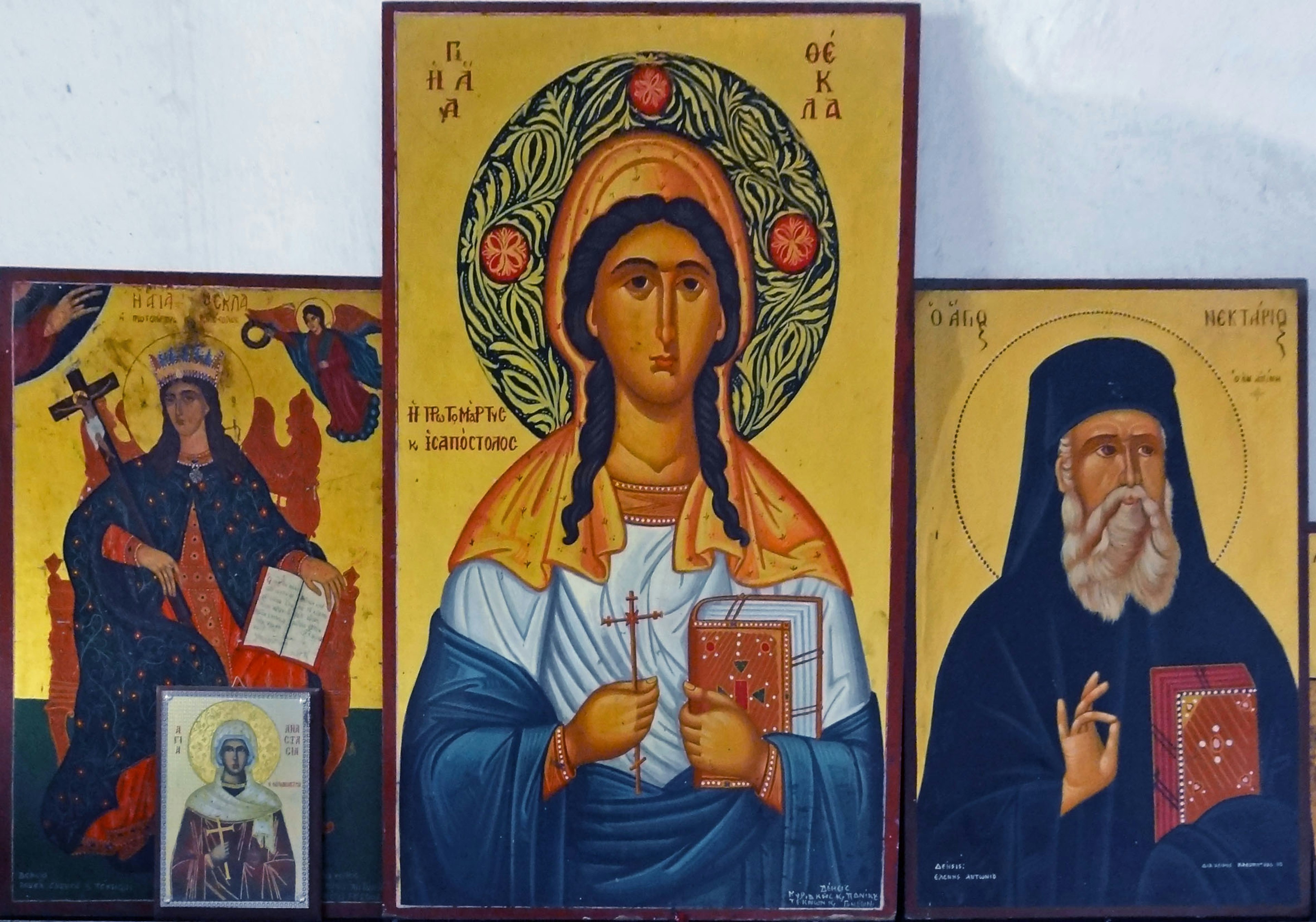 Three religious icons featuring saints and a central figure of the Virgin Mary