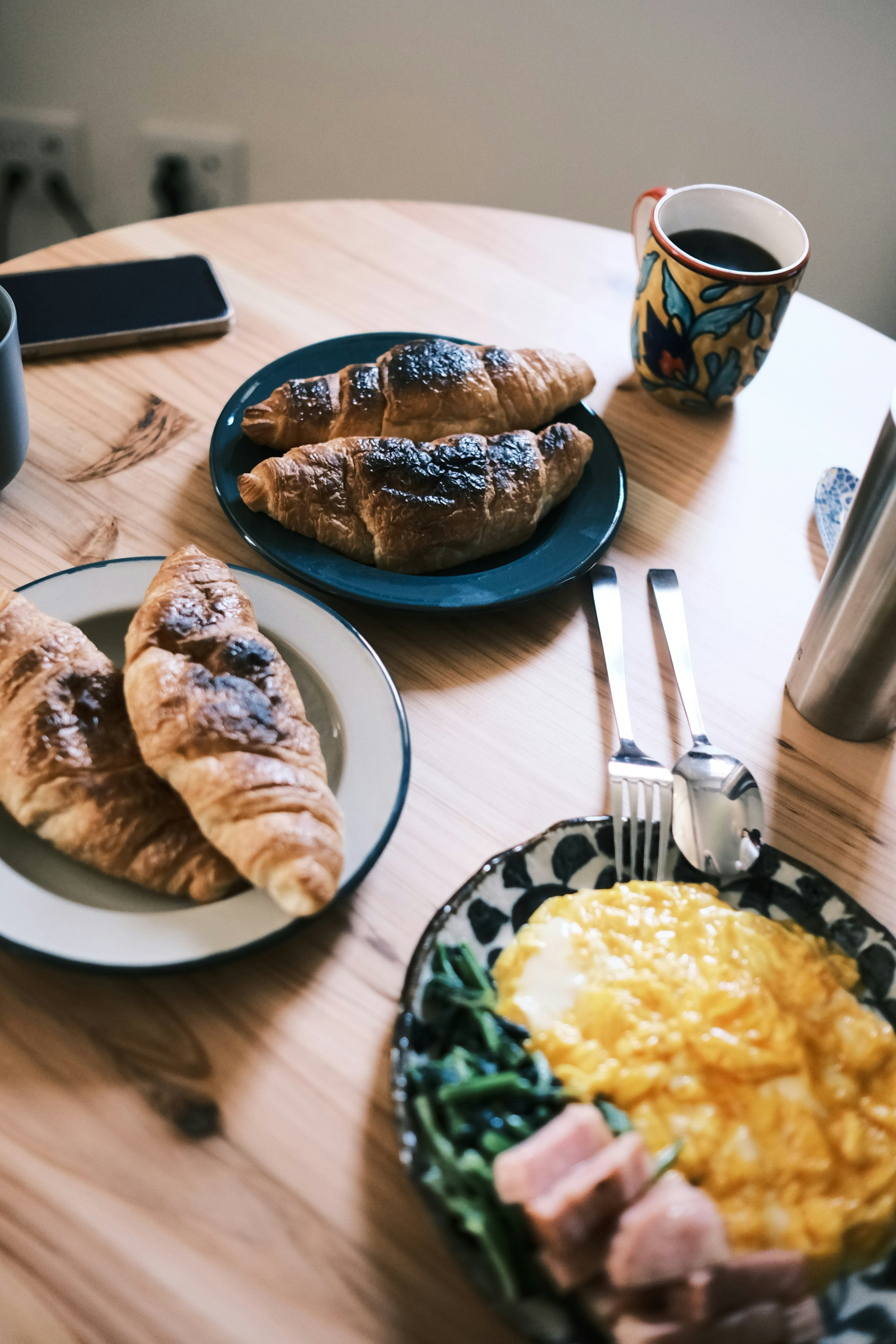 Breakfast table featuring croissants and scrambled eggs