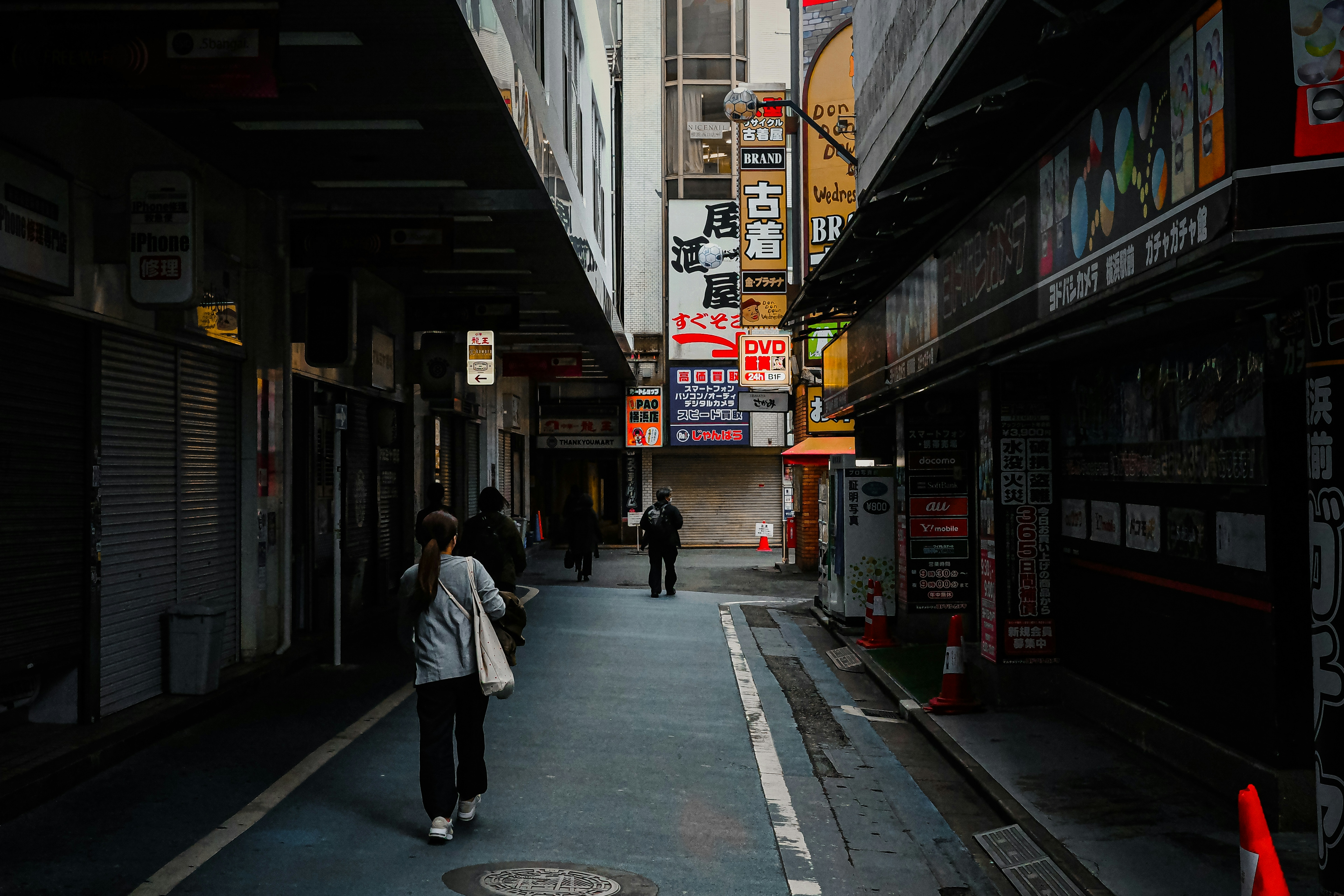 暗い通りに人々が歩いている街の風景