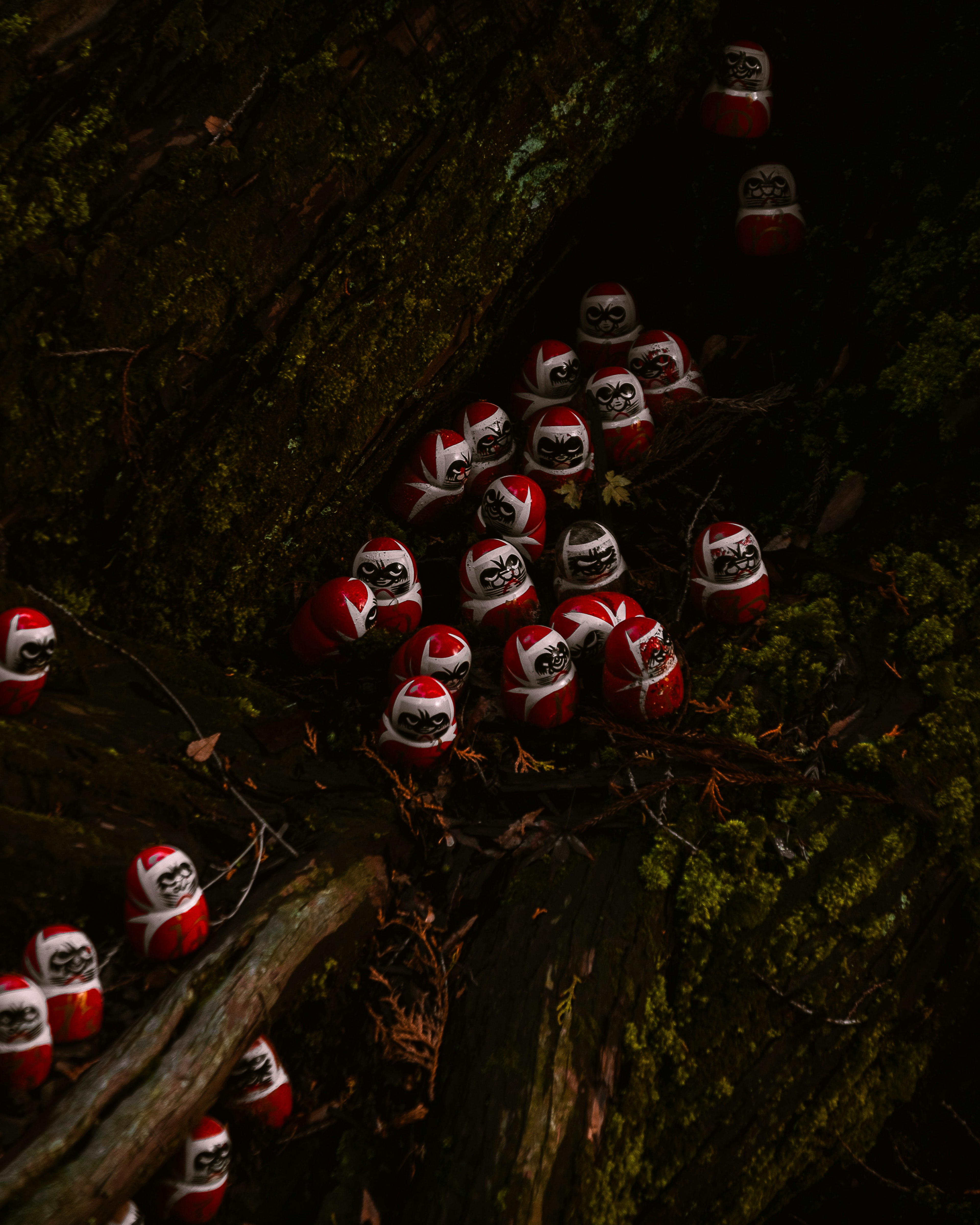 Small red figurines clustered around the trunk of a tree