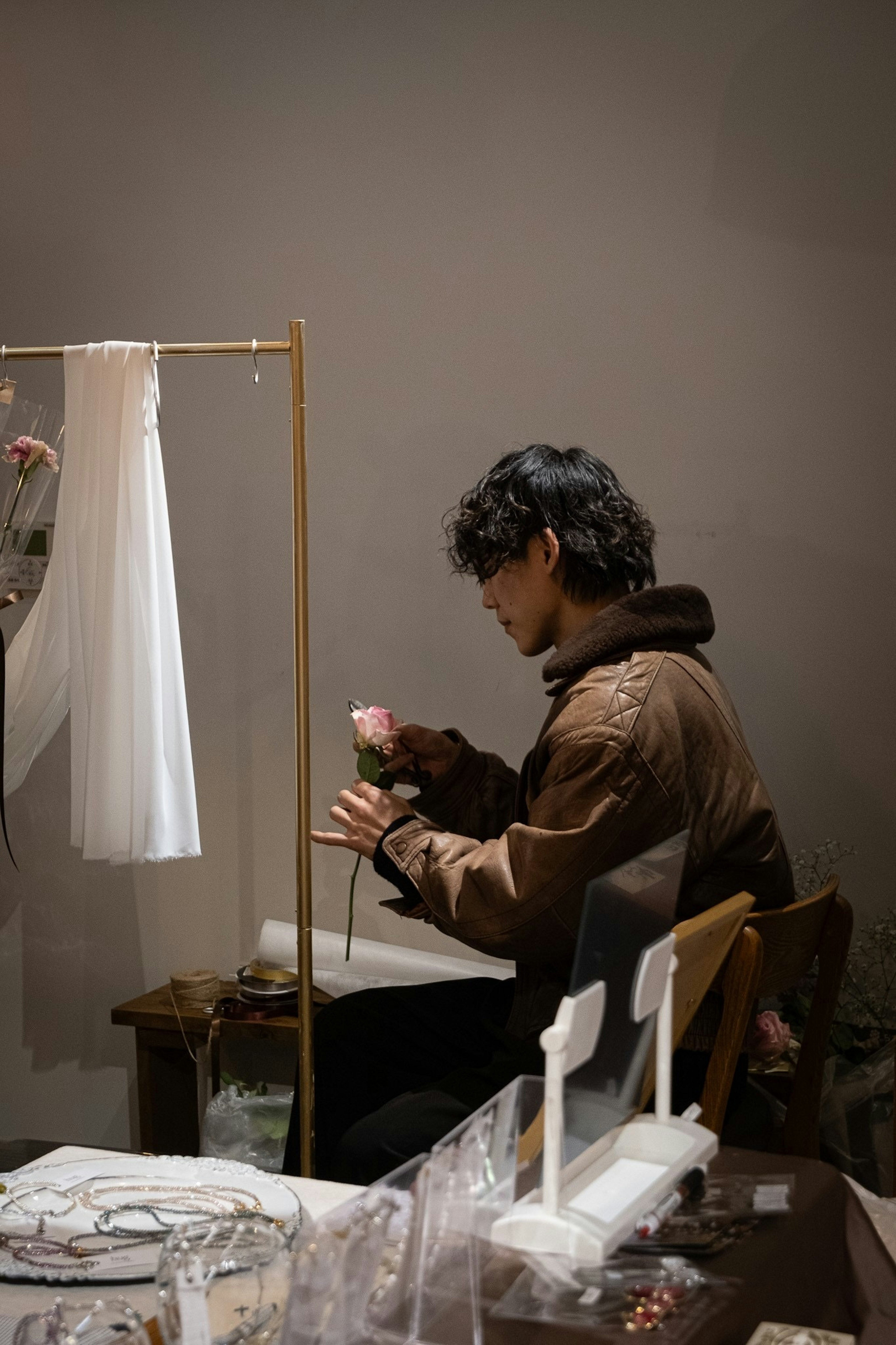 A man creating art with flowers in a minimalistic setting