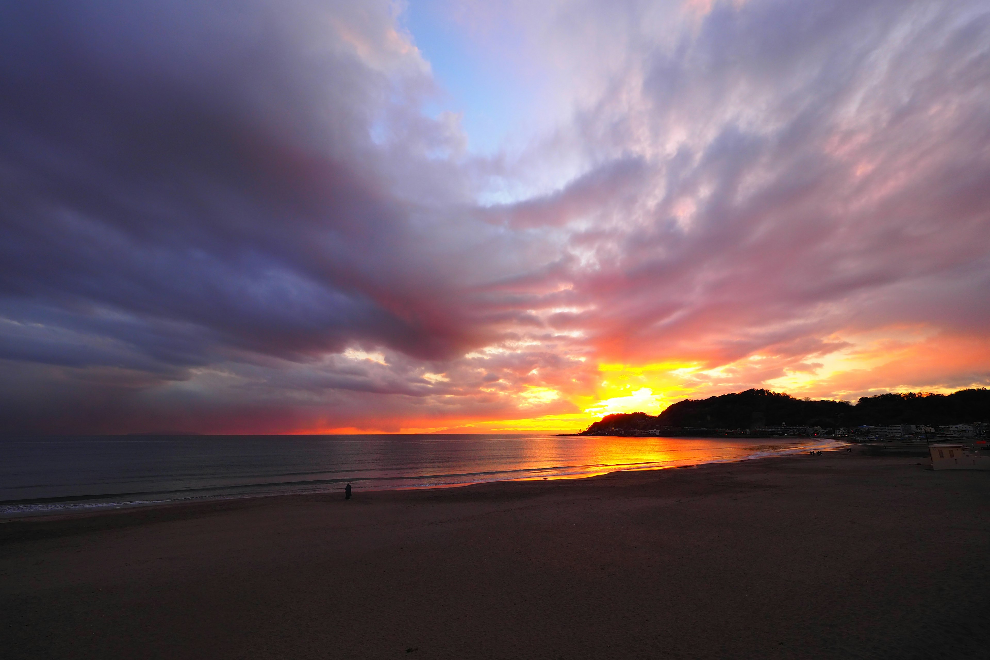 夕焼けの海岸線と雲のドラマティックな色合い