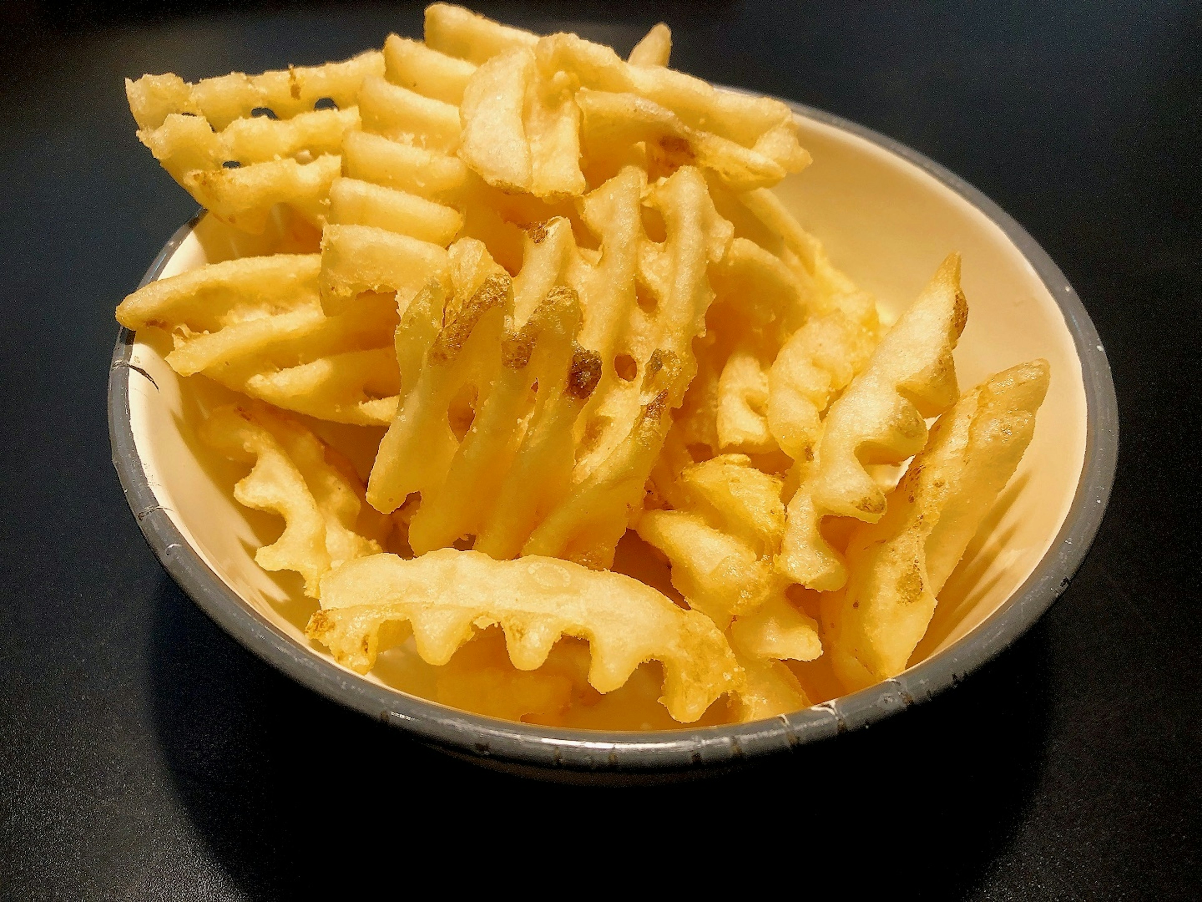 A bowl filled with waffle fries