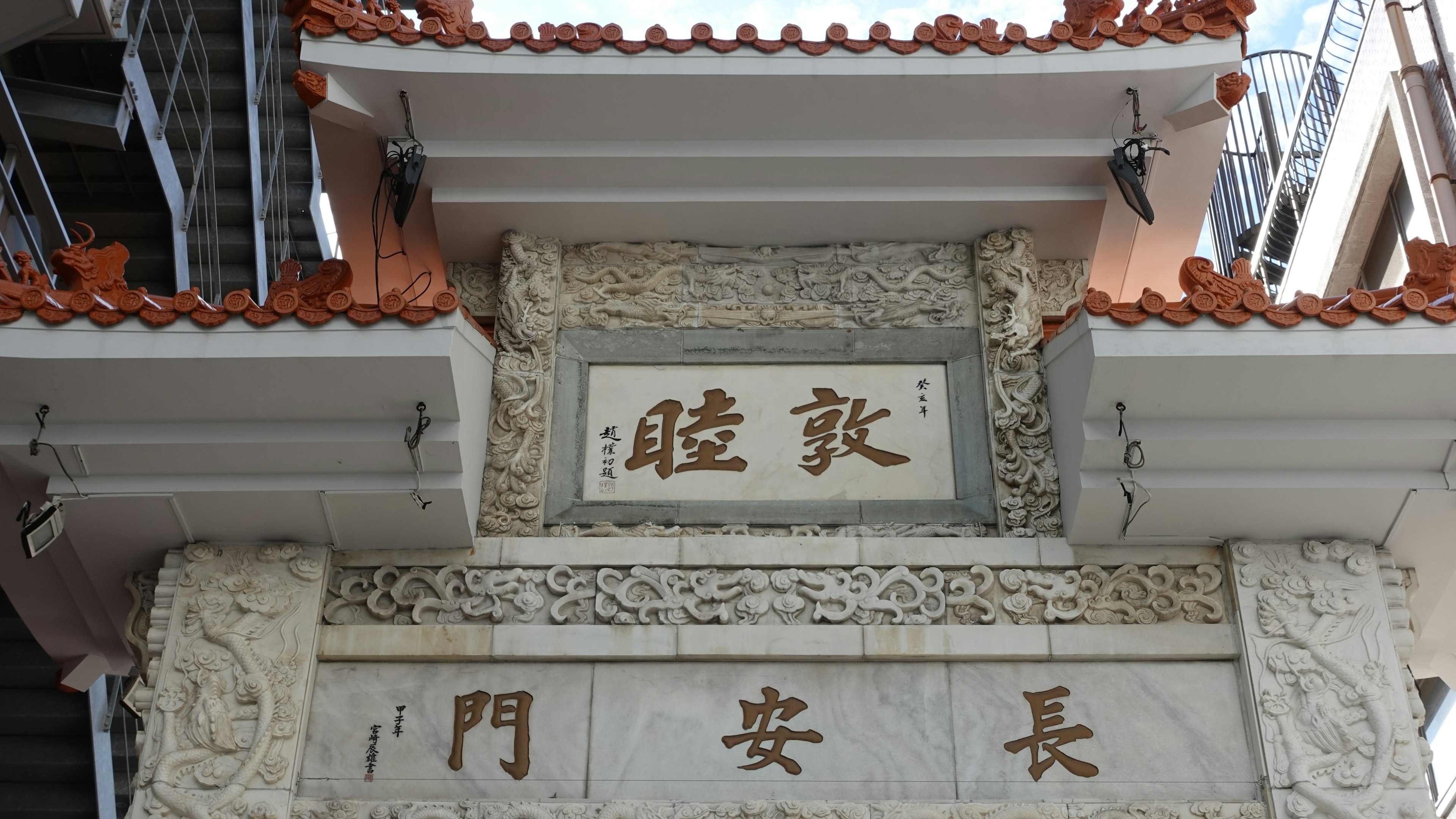 Decorative carvings and Chinese characters on the upper part of a traditional Chinese gate