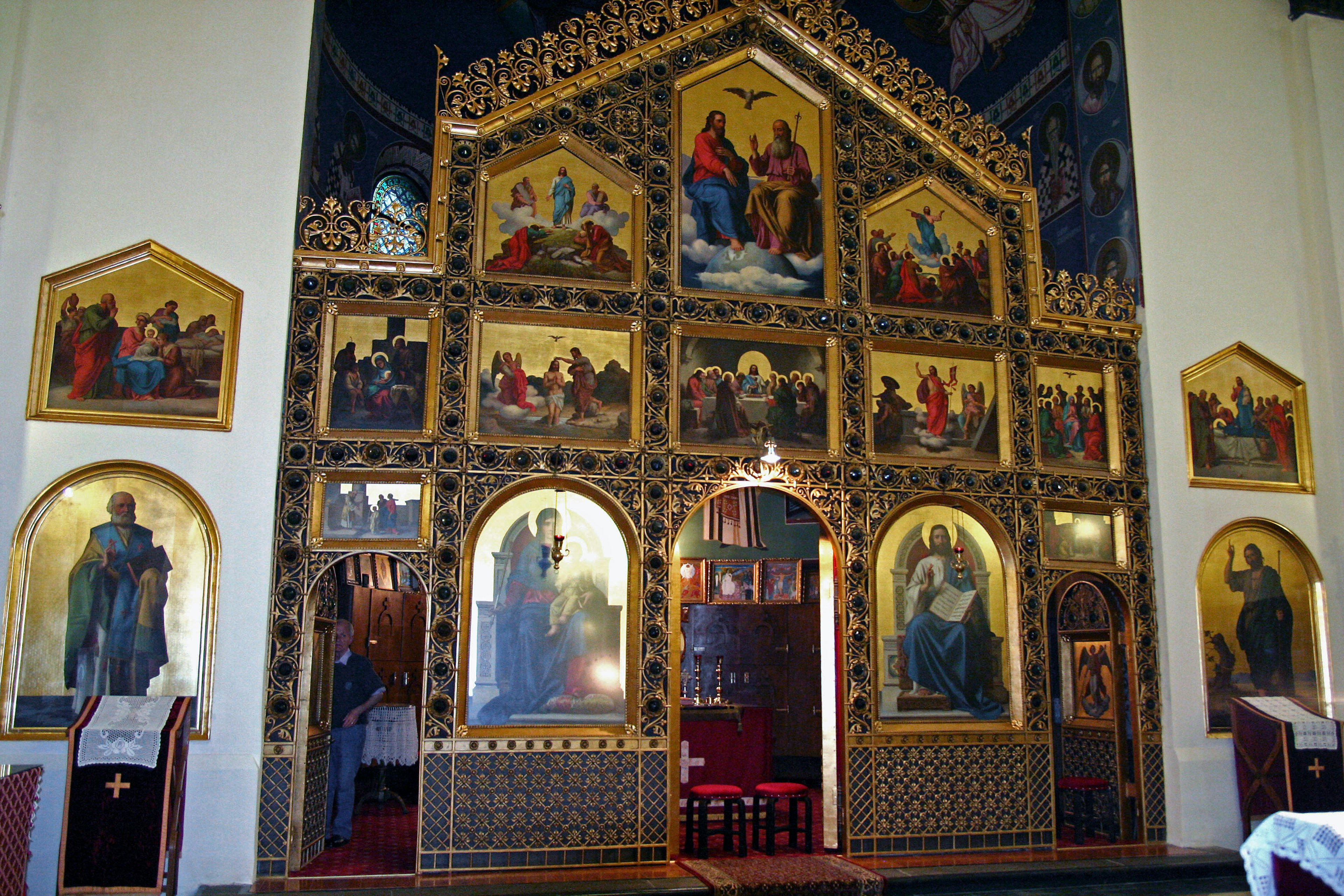 Interior of a church featuring a beautiful gilded altar with multiple religious icons