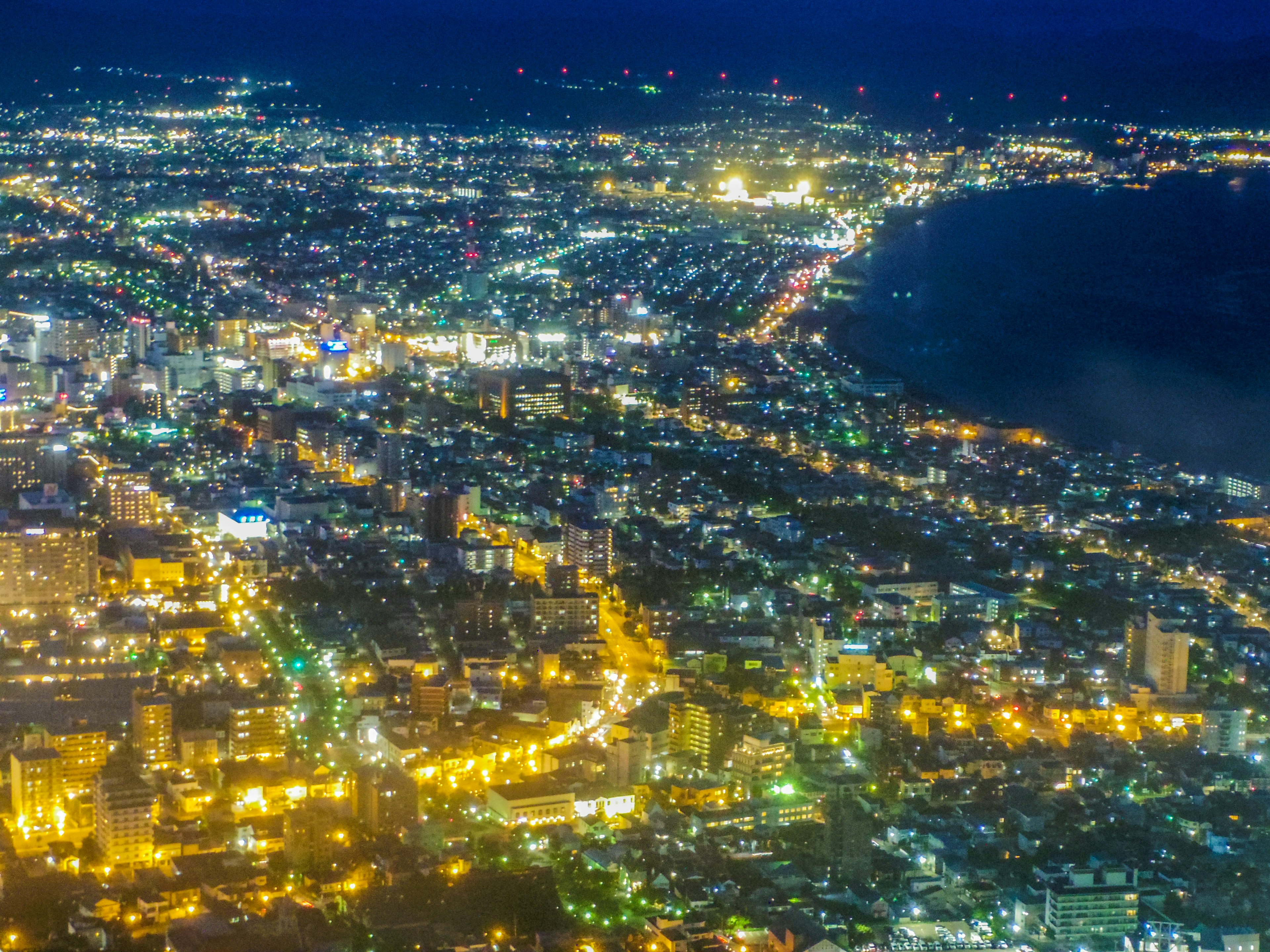 Paisaje urbano nocturno con edificios y calles iluminadas