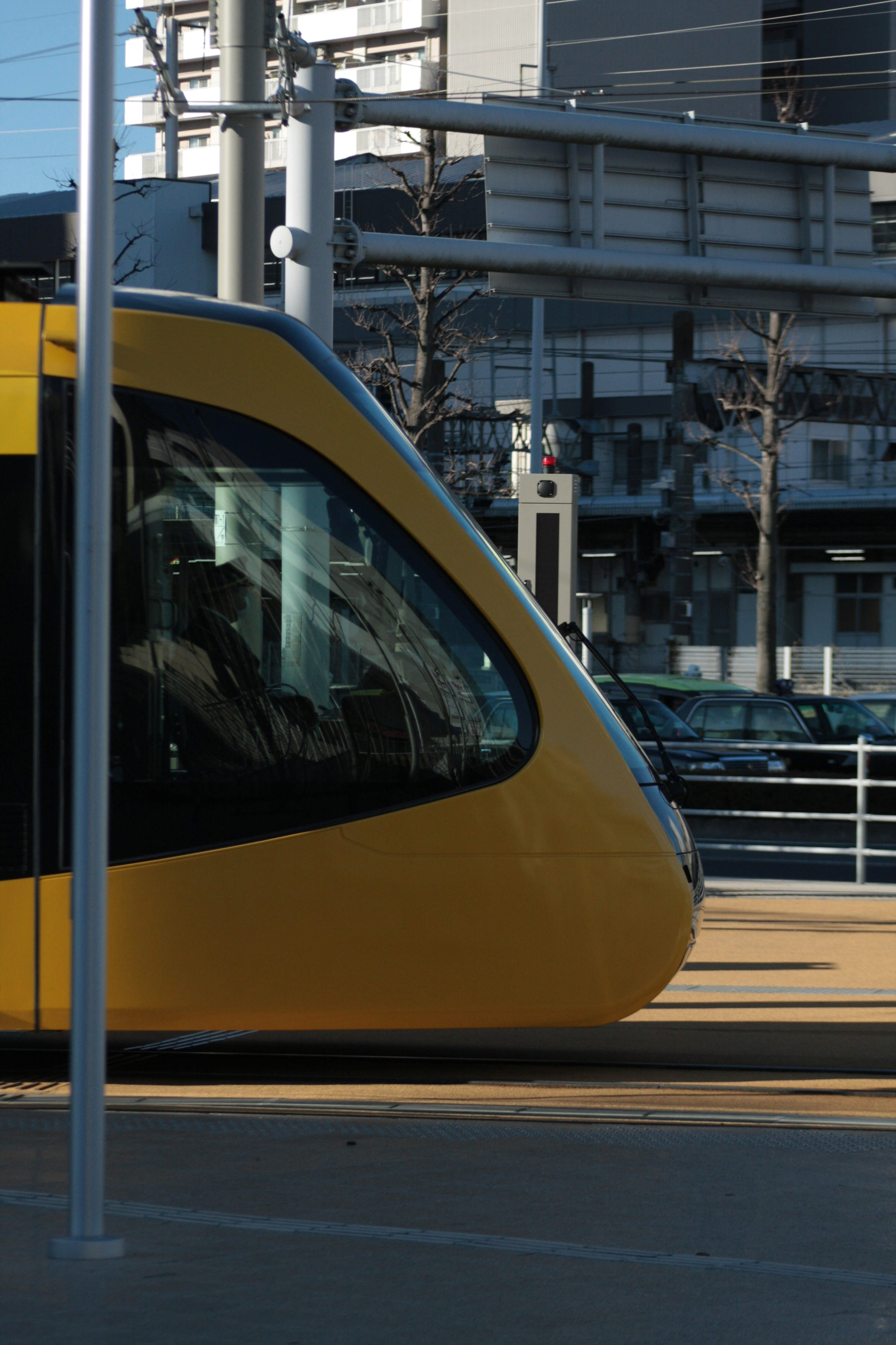 Close-up of a yellow tram with urban buildings in the background