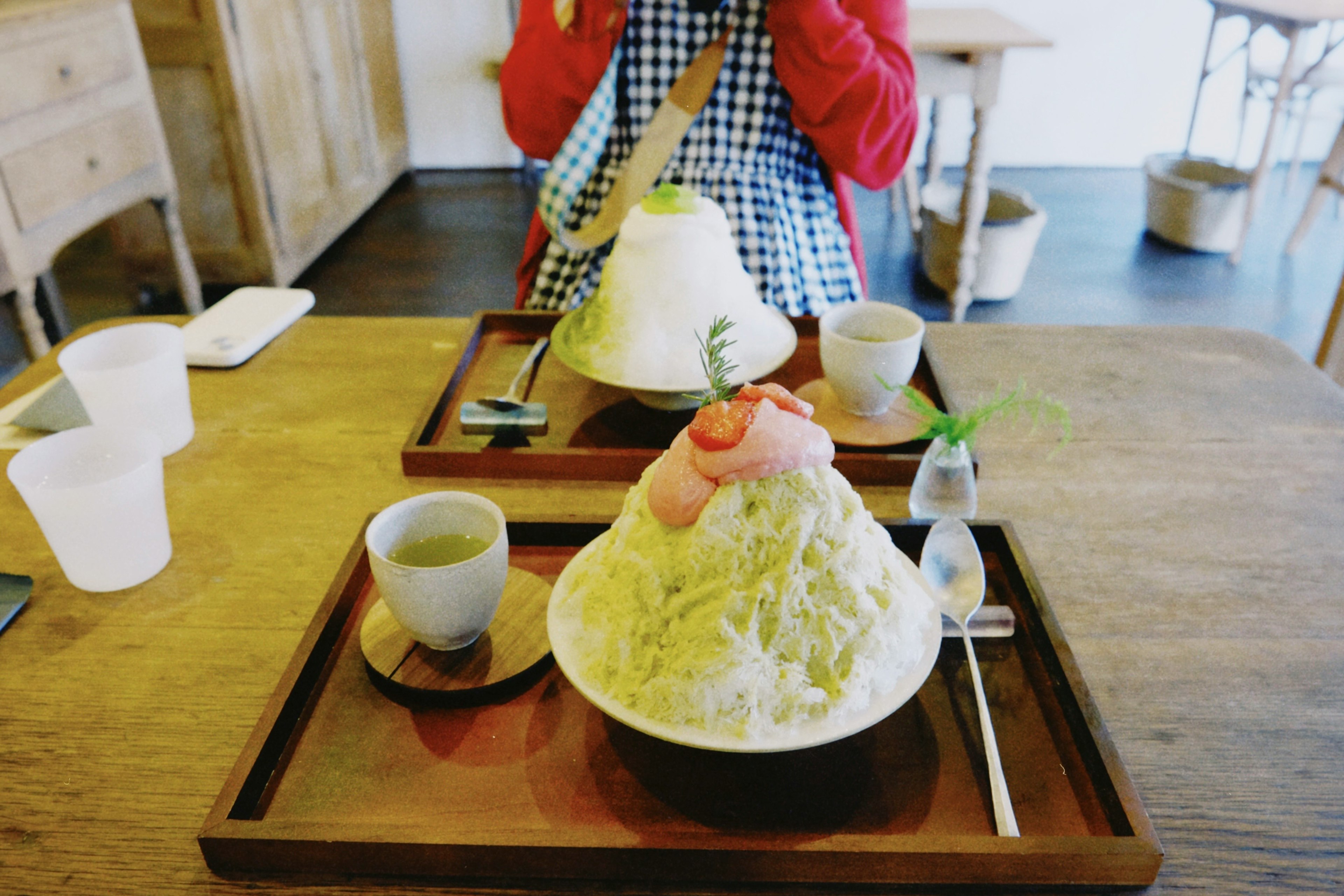 Two bowls of shaved ice on a wooden table