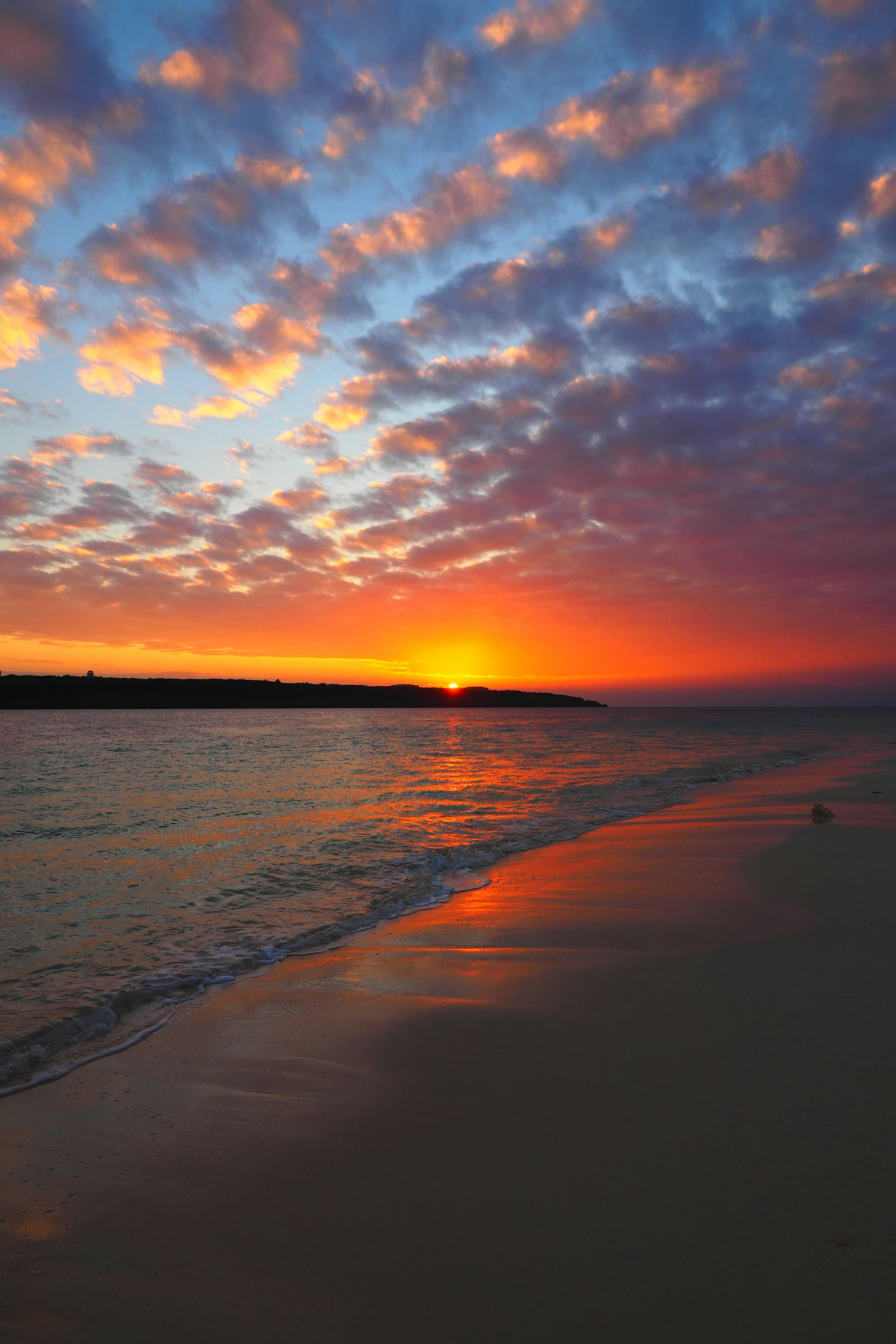 Schöne Landschaft mit Sonnenuntergang über dem Meer und bunten Wolken