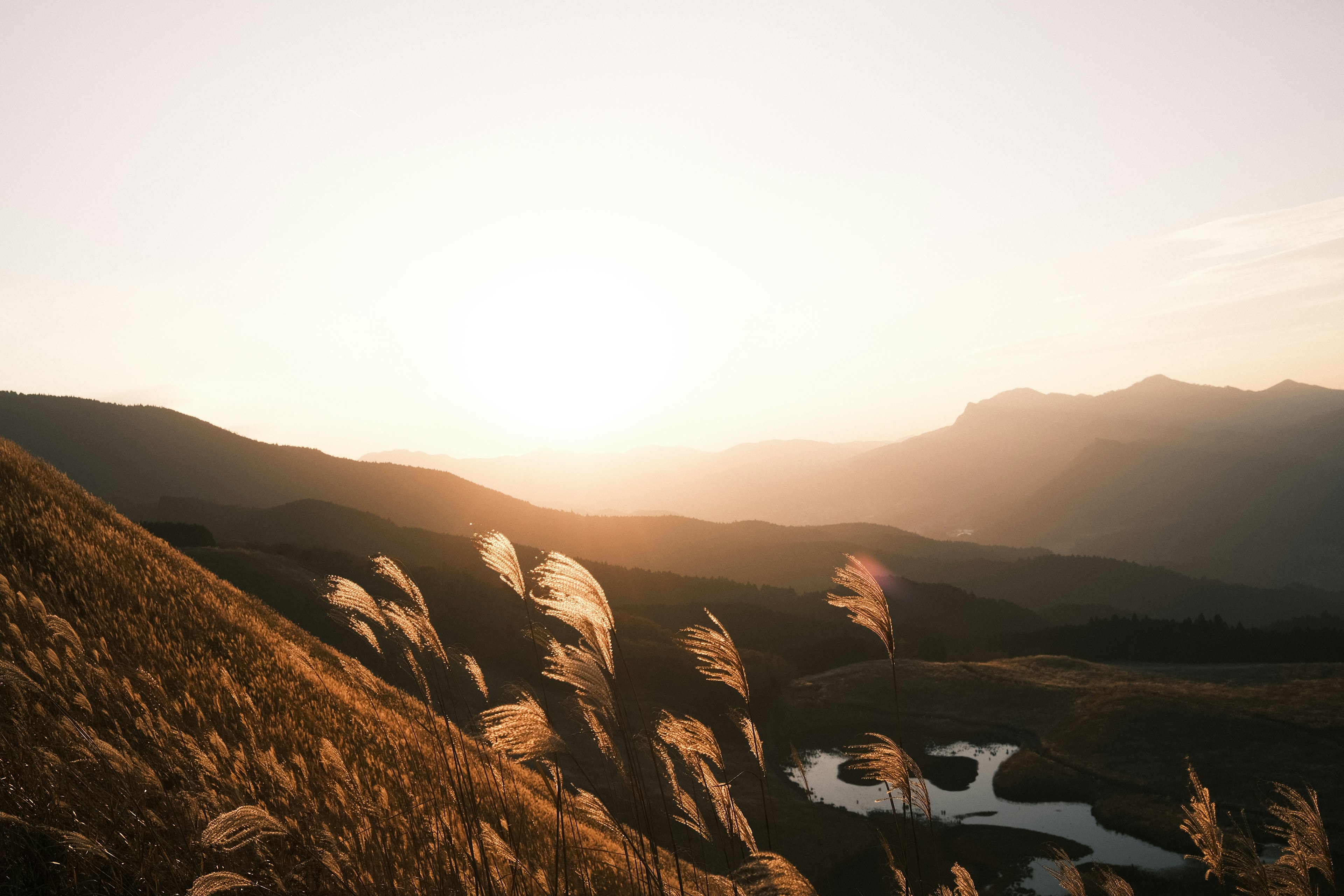 Vue panoramique des montagnes et d'un champ au coucher du soleil