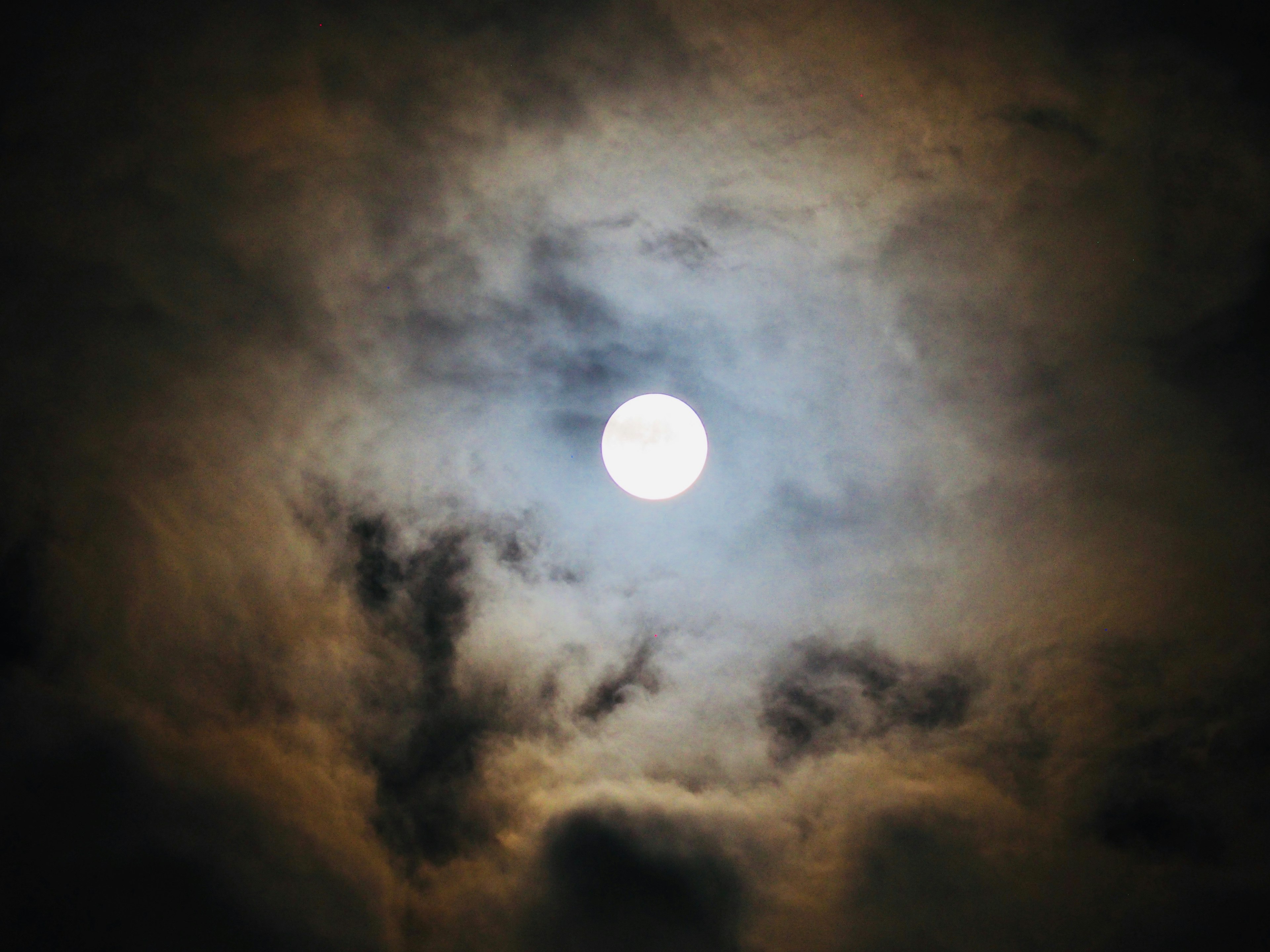 Luna brillante rodeada de nubes oscuras