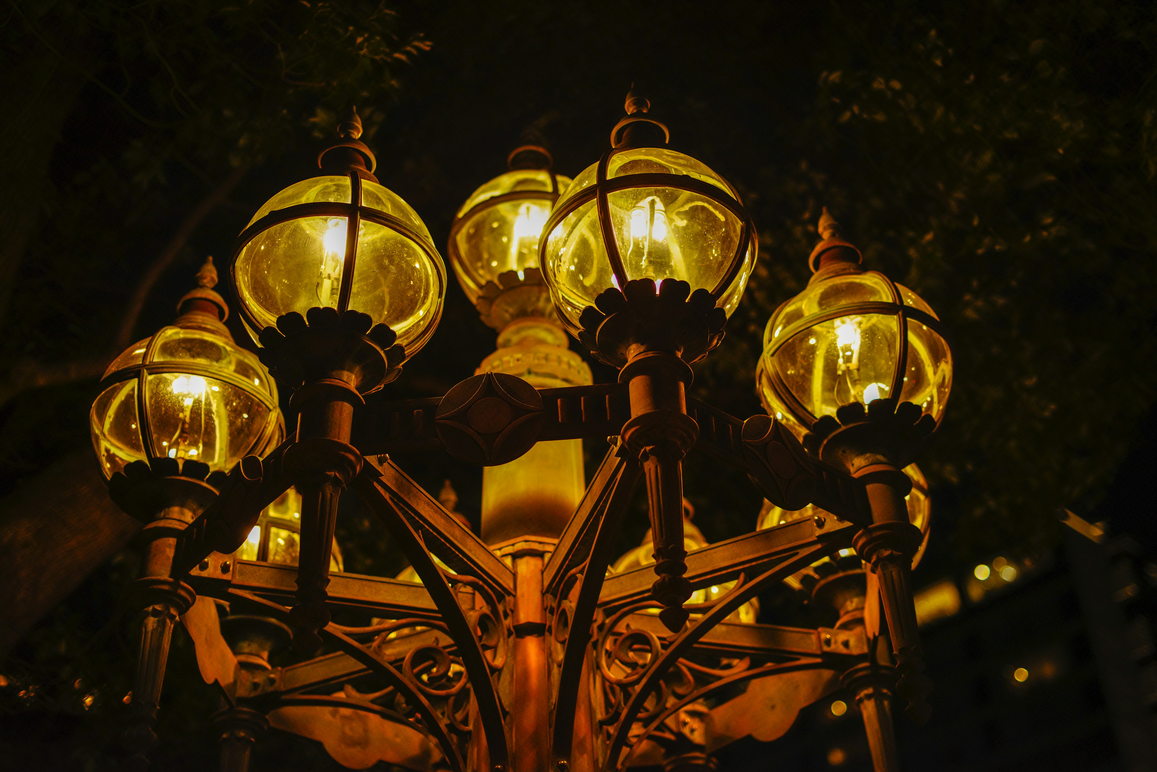 Close-up of a vintage street lamp at night with glowing glass globes