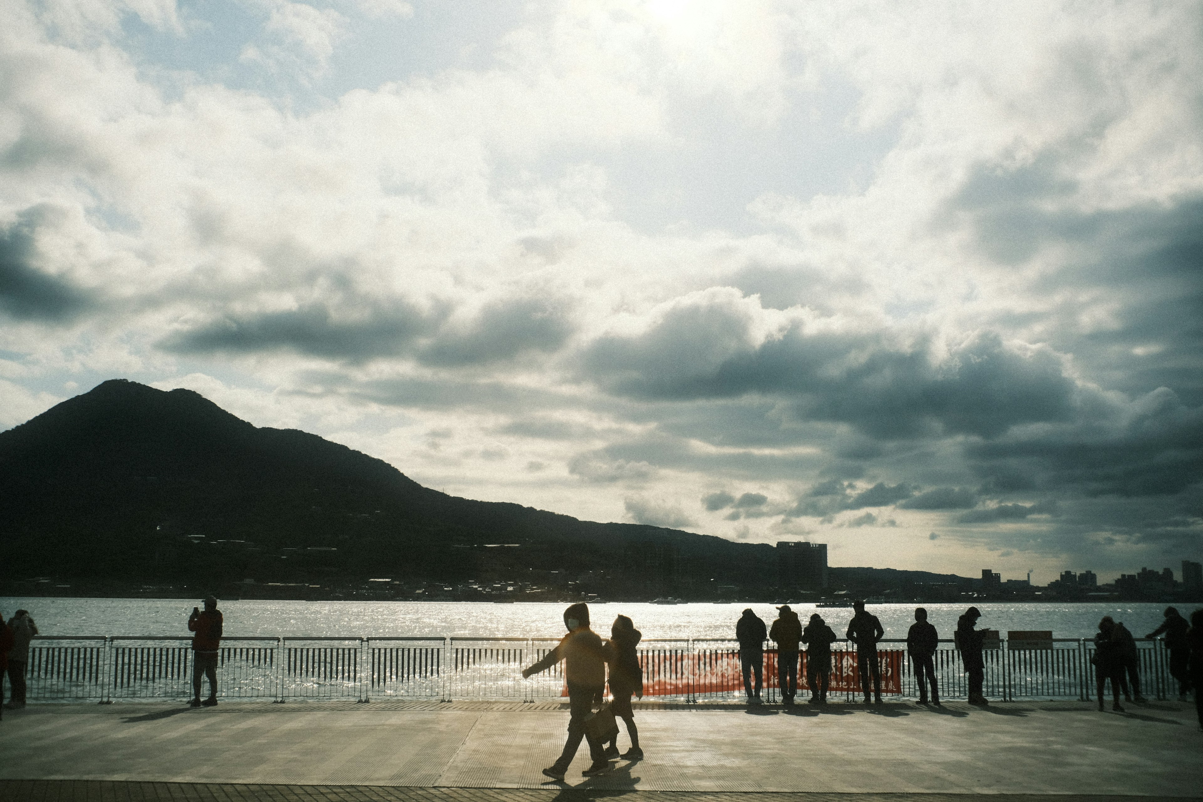 海辺で散歩する人々と山の風景