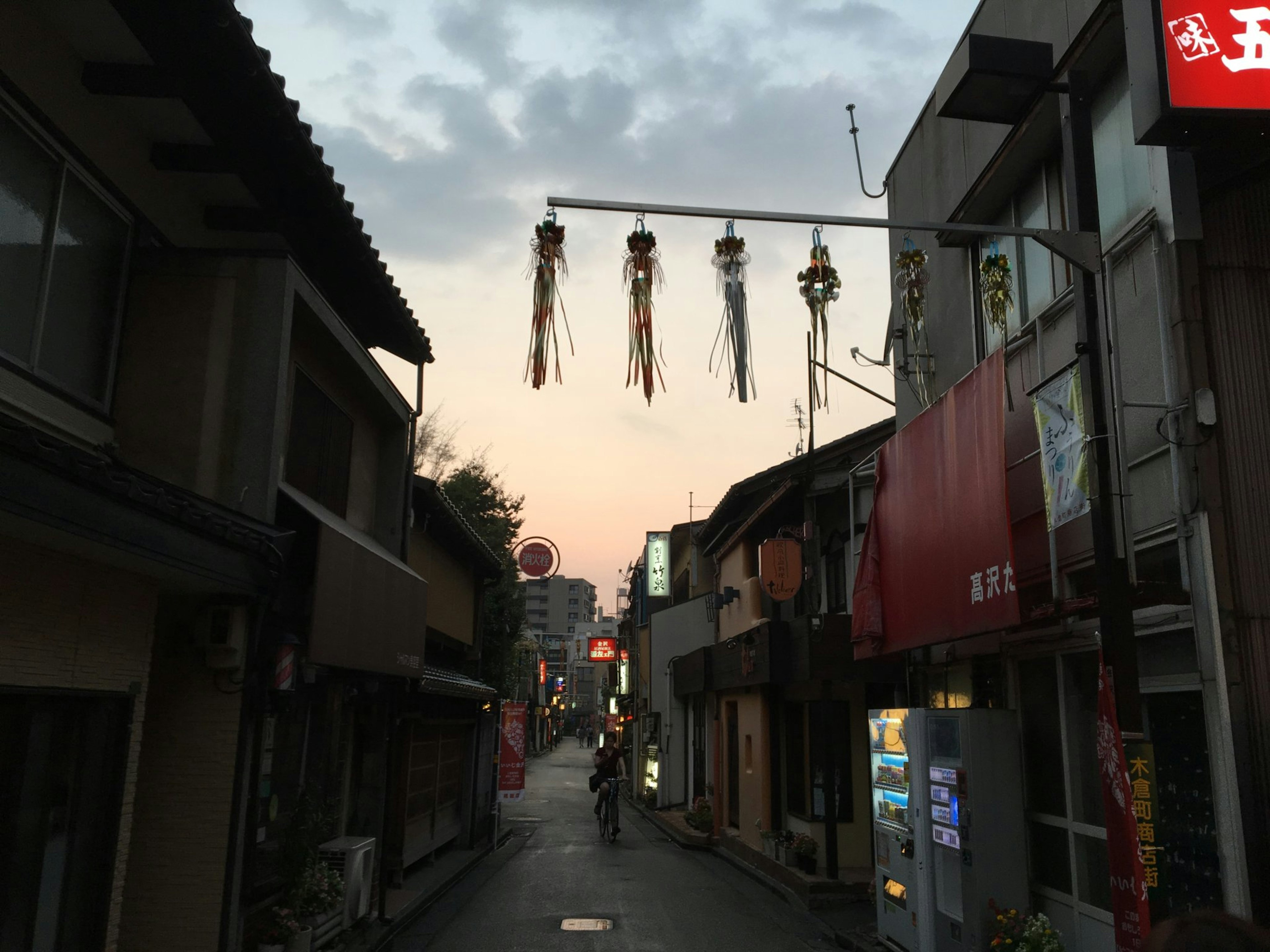 夕暮れ時の日本の街並みに飾られた風鈴のアーチ