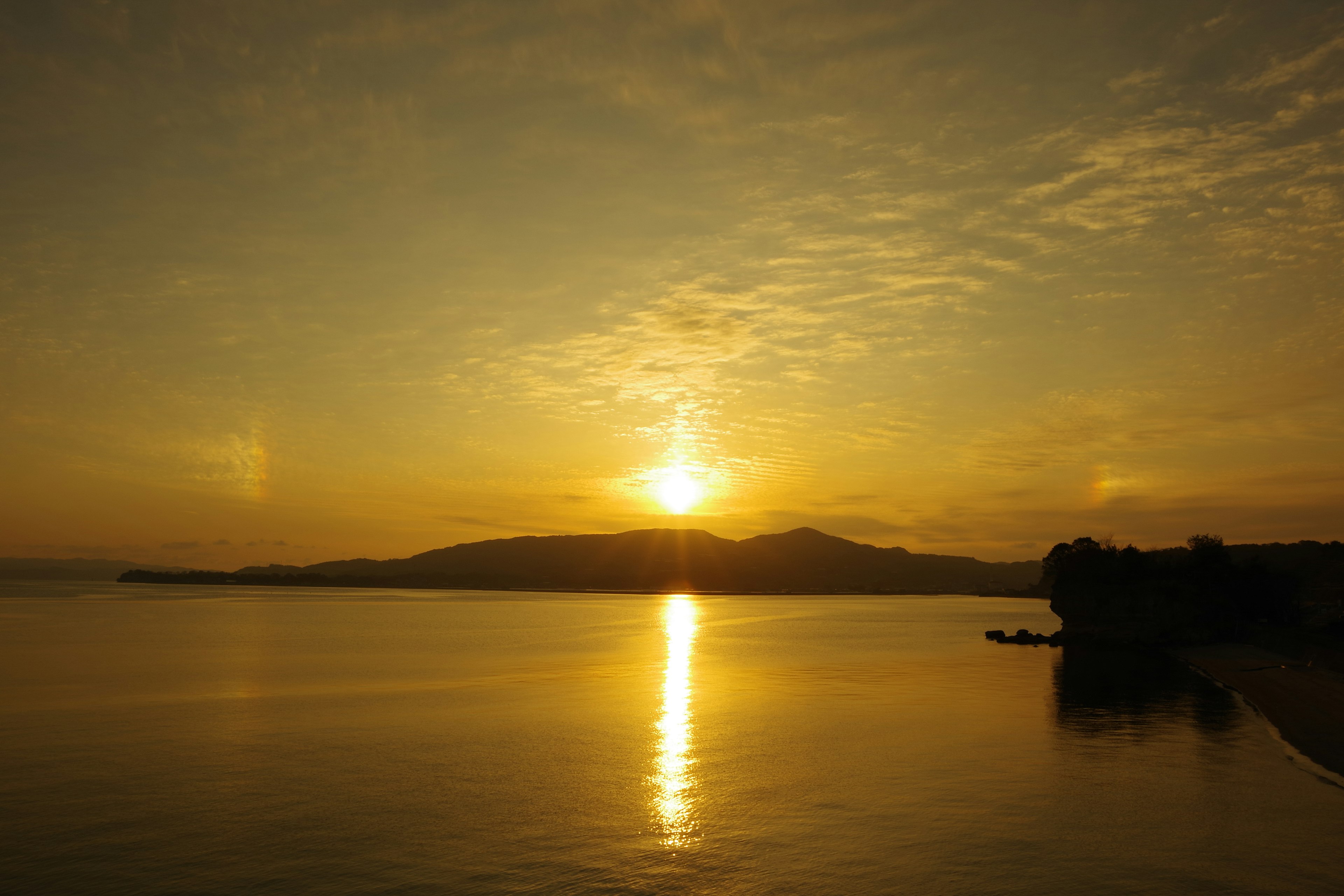 Paysage magnifique du coucher de soleil sur les montagnes avec un reflet orange chaud sur l'eau calme