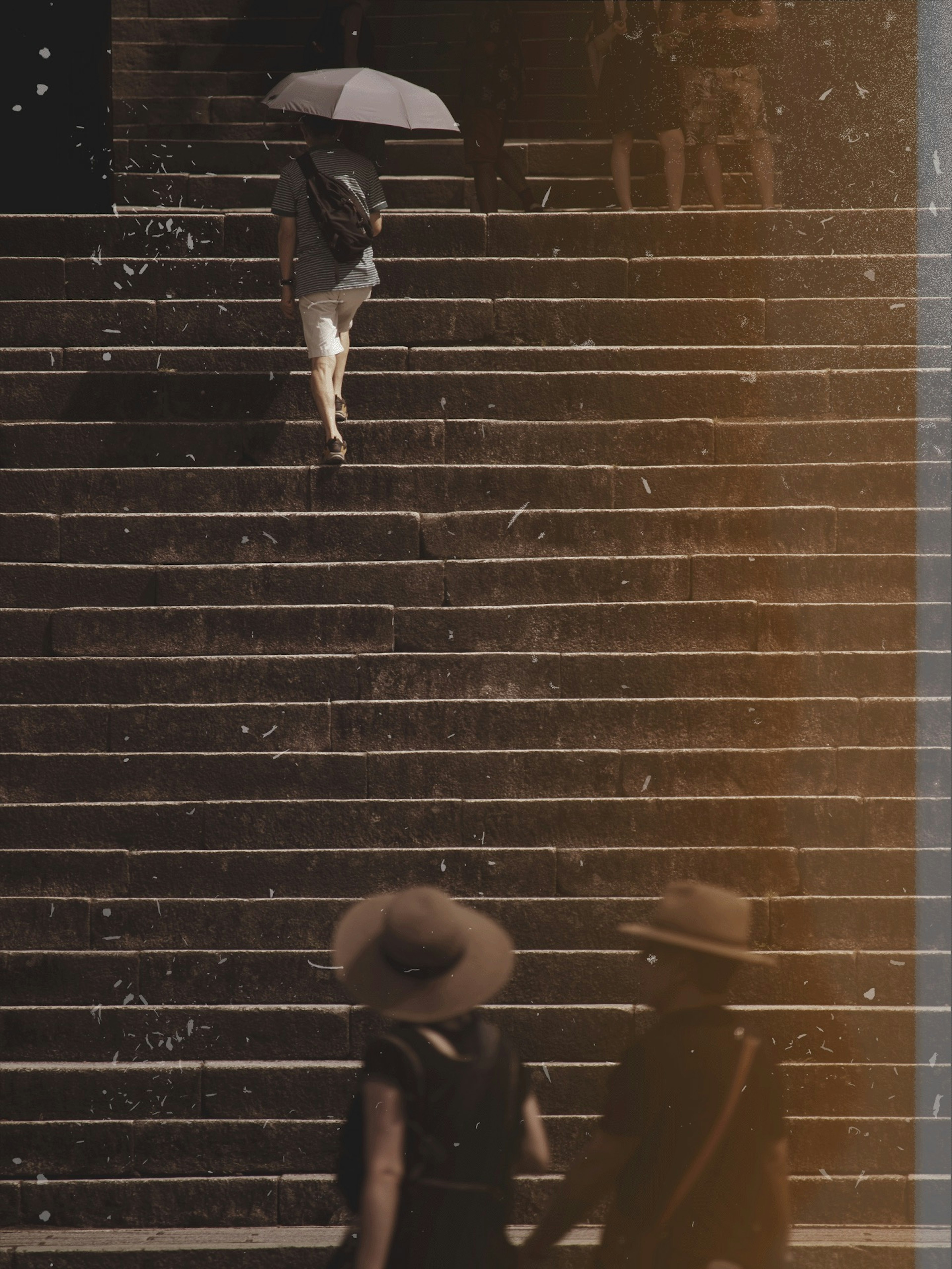 Personne avec un parapluie montant des escaliers avec deux personnes en chapeaux en bas