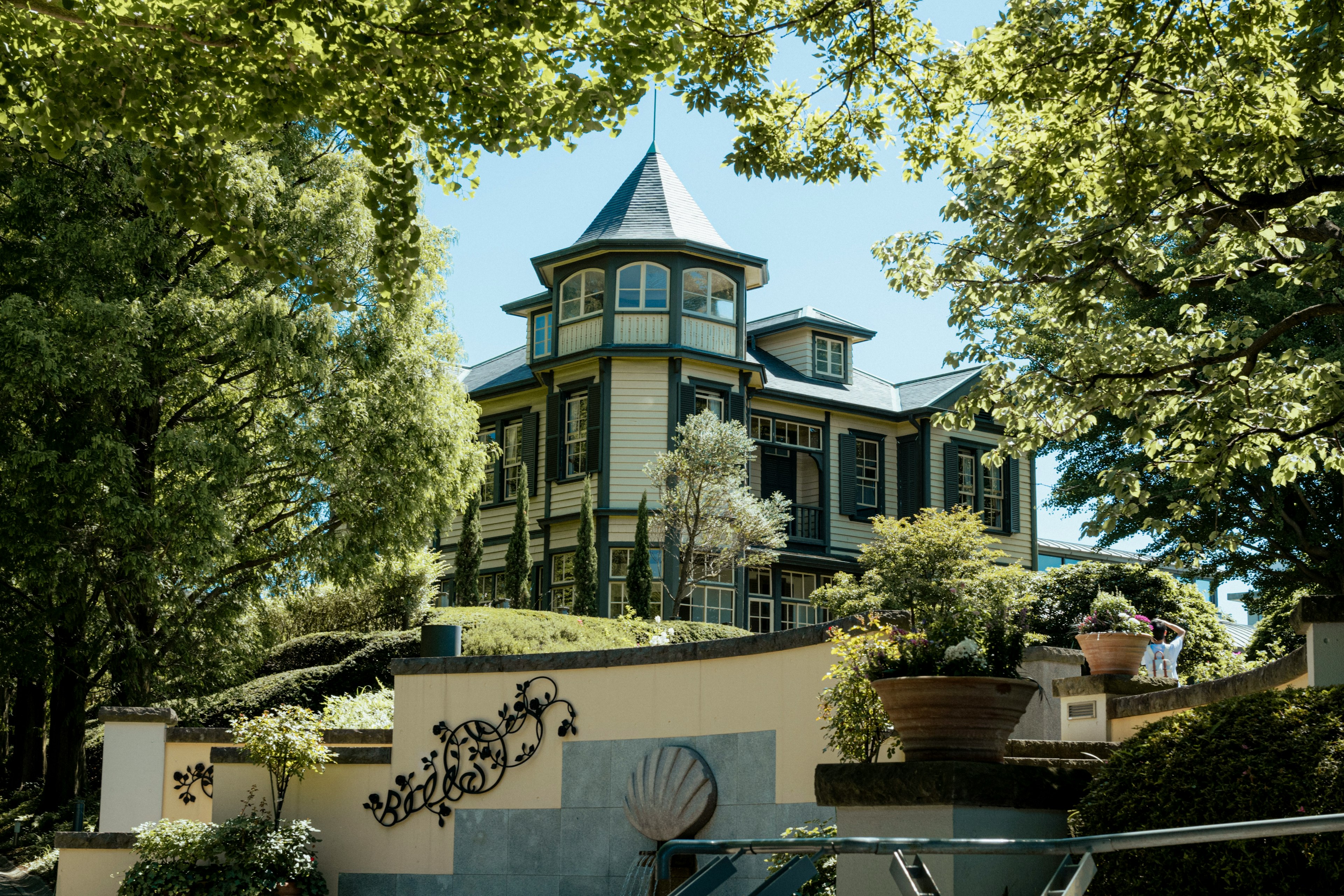 Maison historique avec façade bleue entourée d'un jardin luxuriant