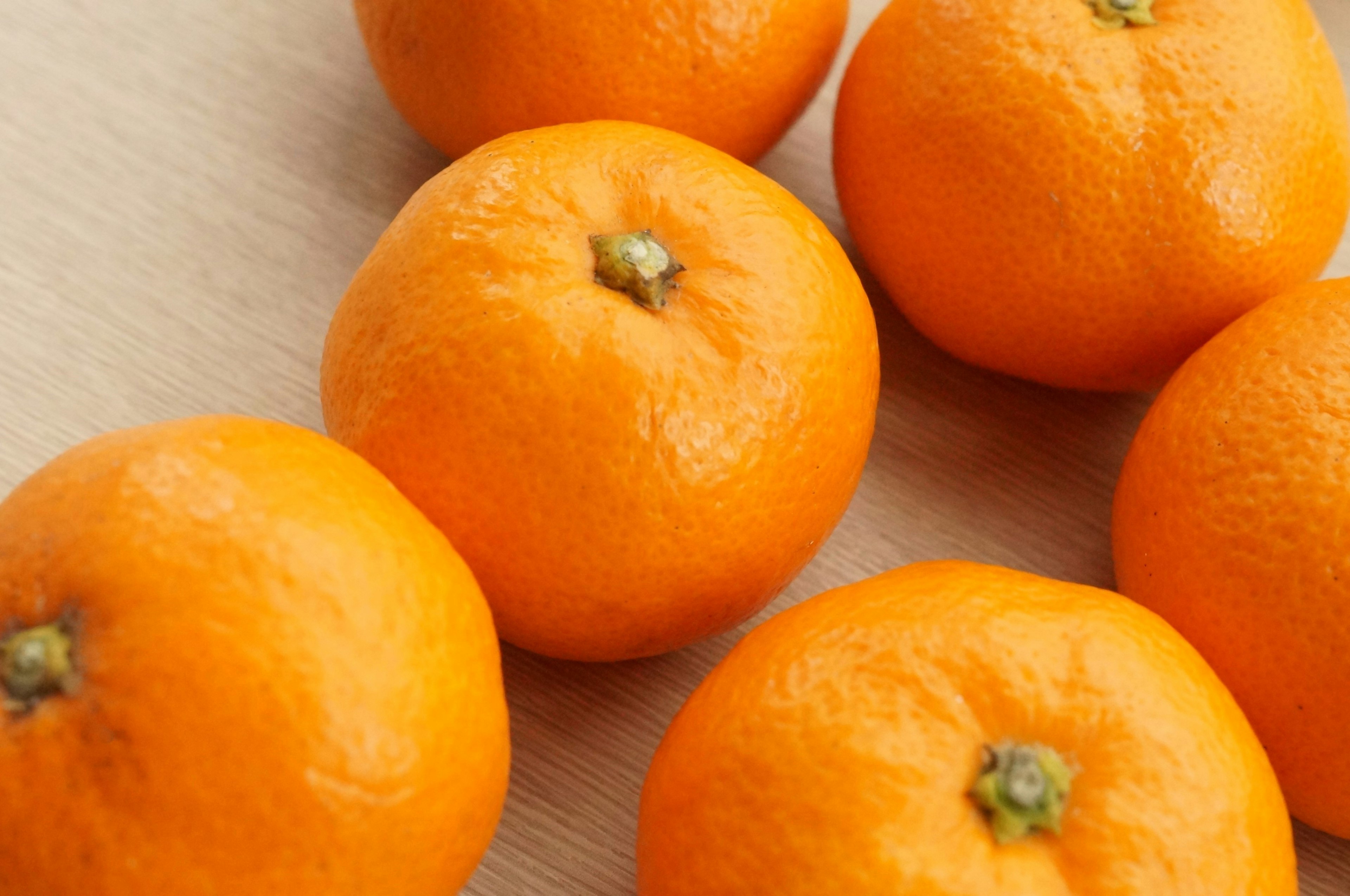 Vibrant orange mandarins arranged on a wooden table