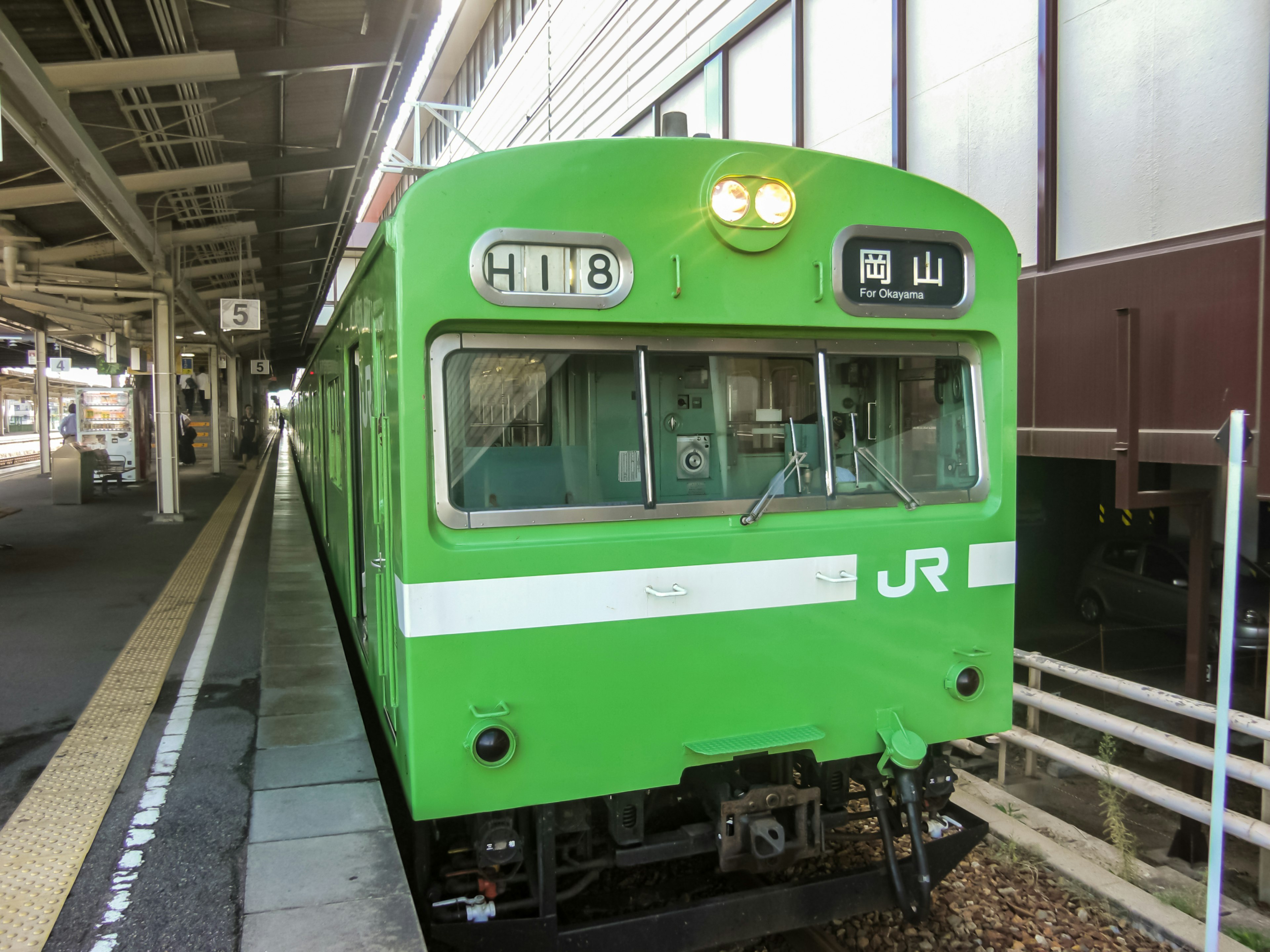 Treno JR verde su una banchina della stazione