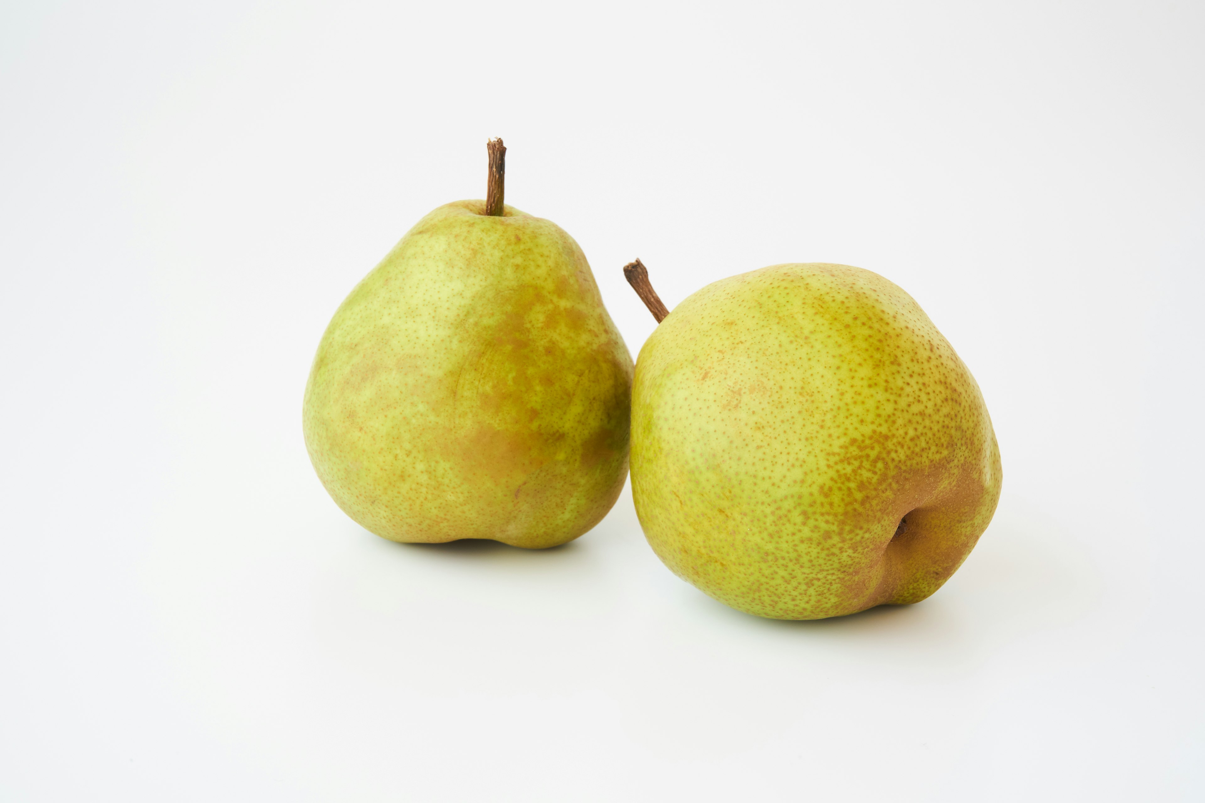 Two green pears placed on a white background