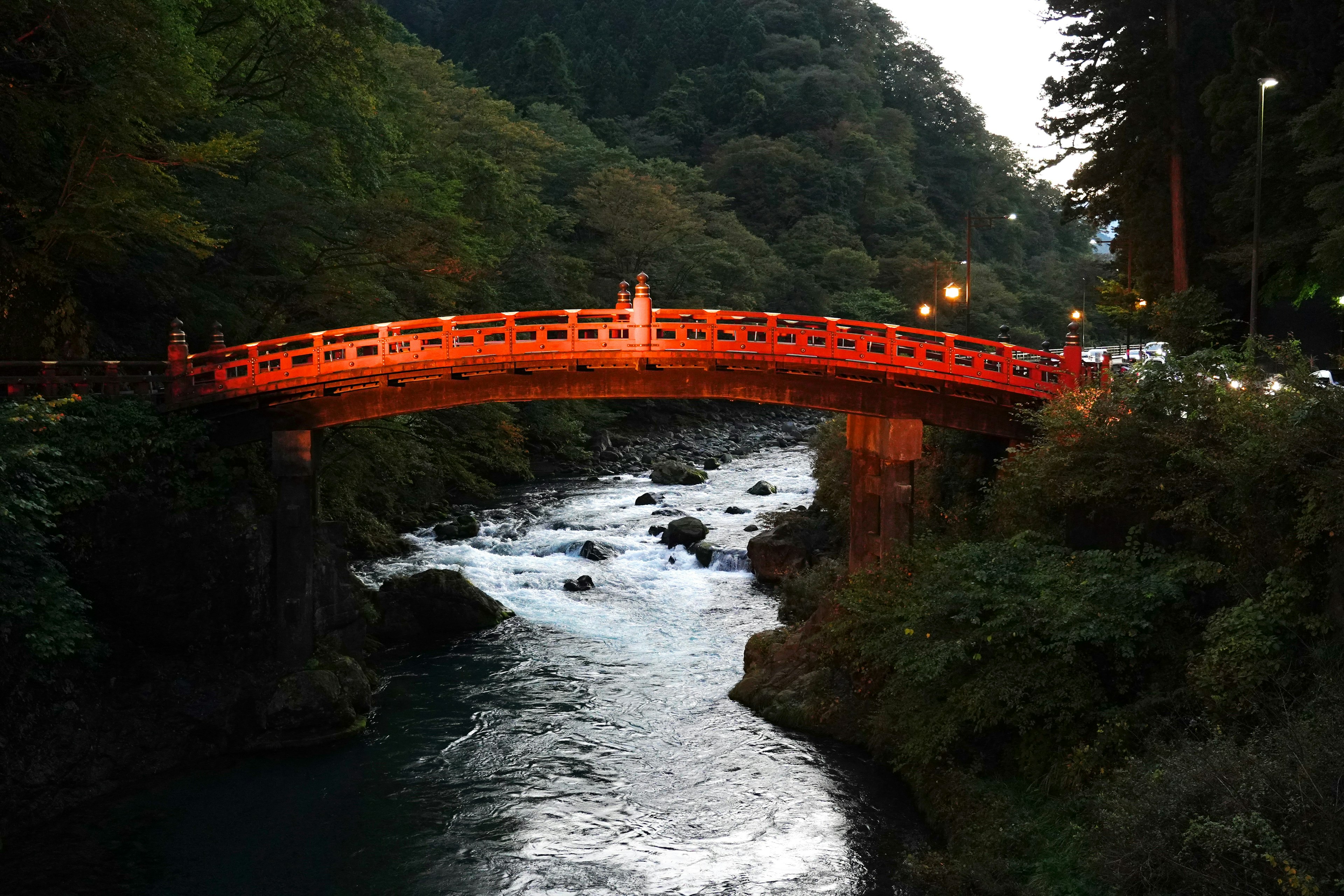 Un hermoso puente rojo que cruza un río que fluye