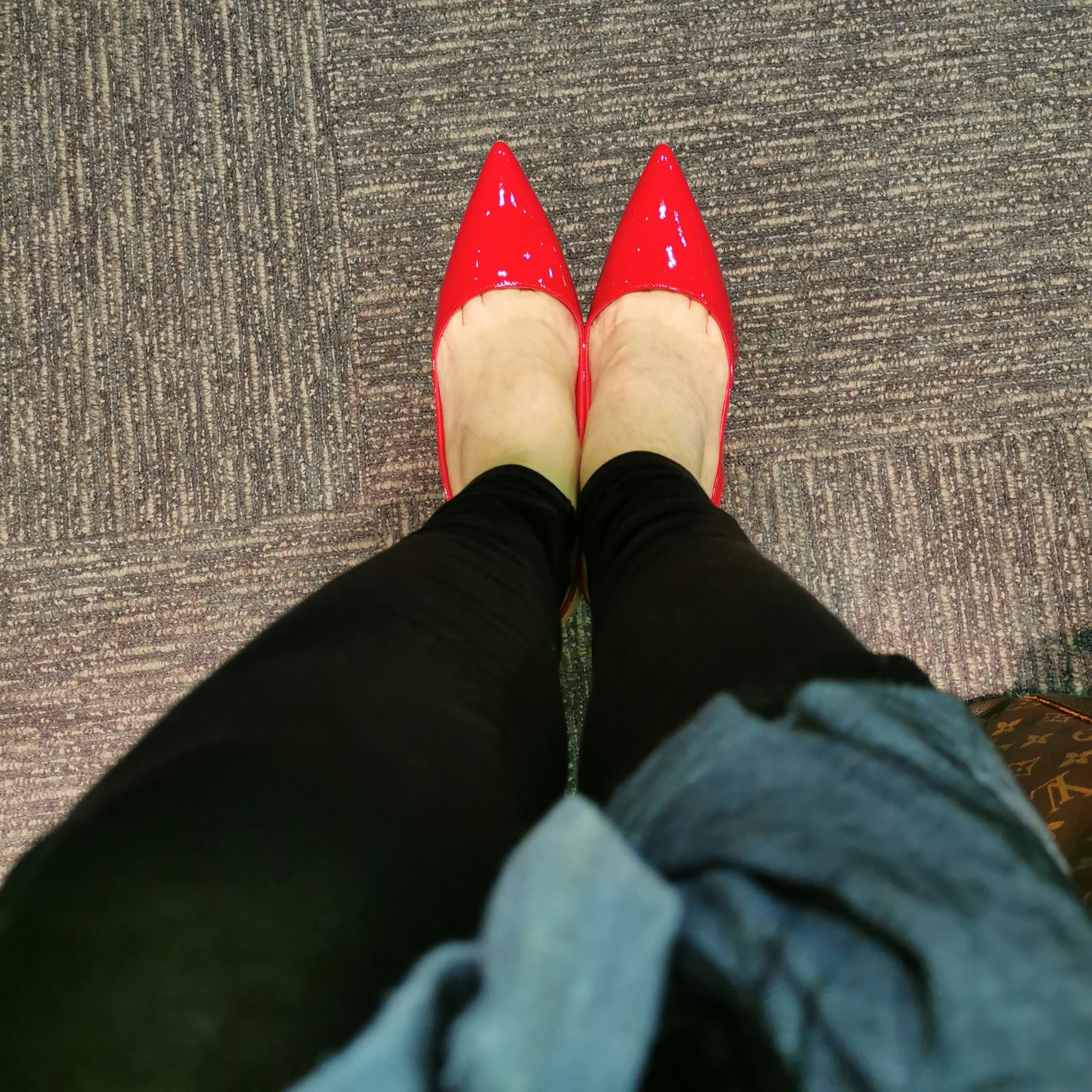 Feet in red high heels with black leggings