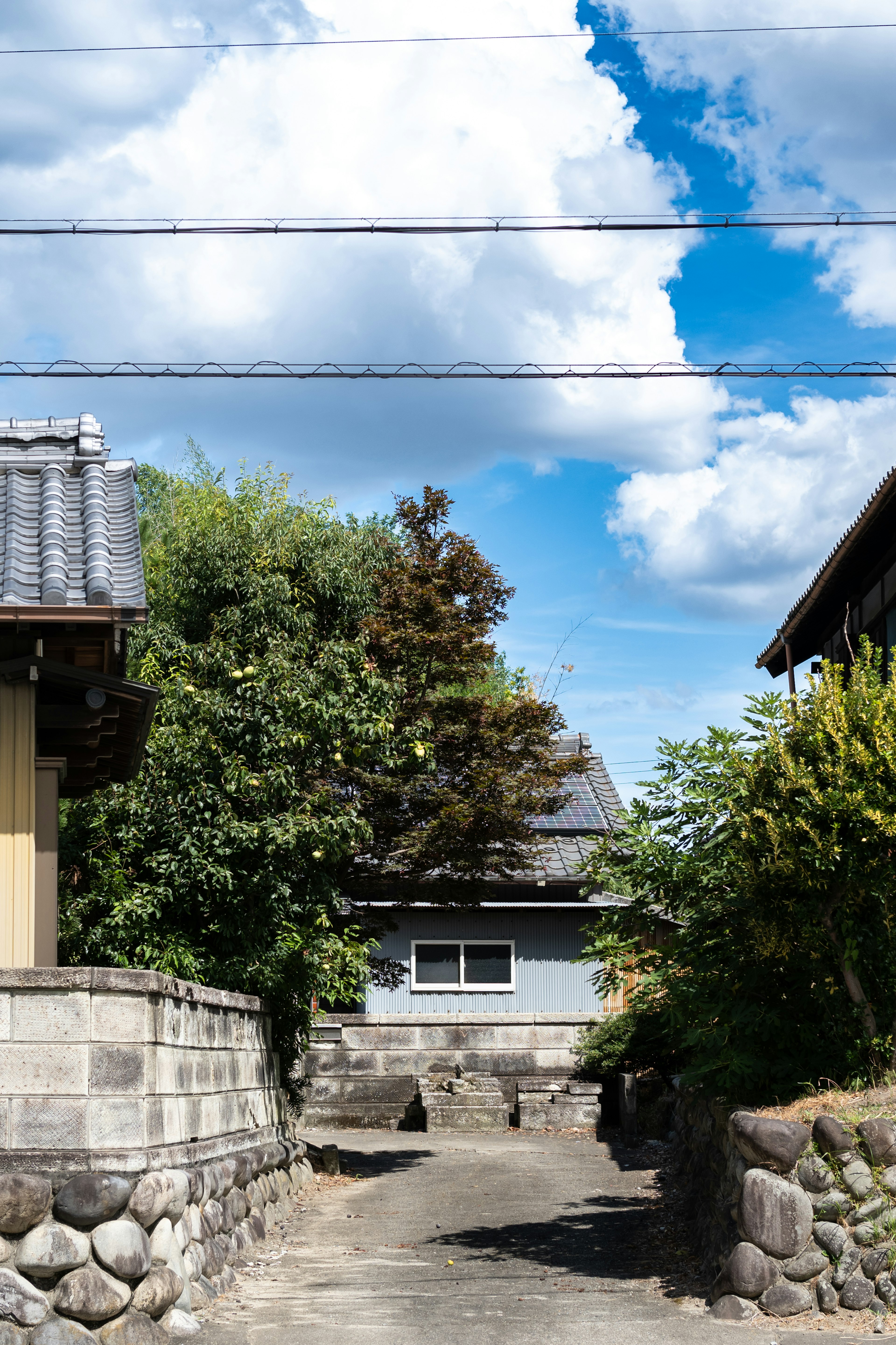 青空と雲に囲まれた静かな日本の住宅街の風景