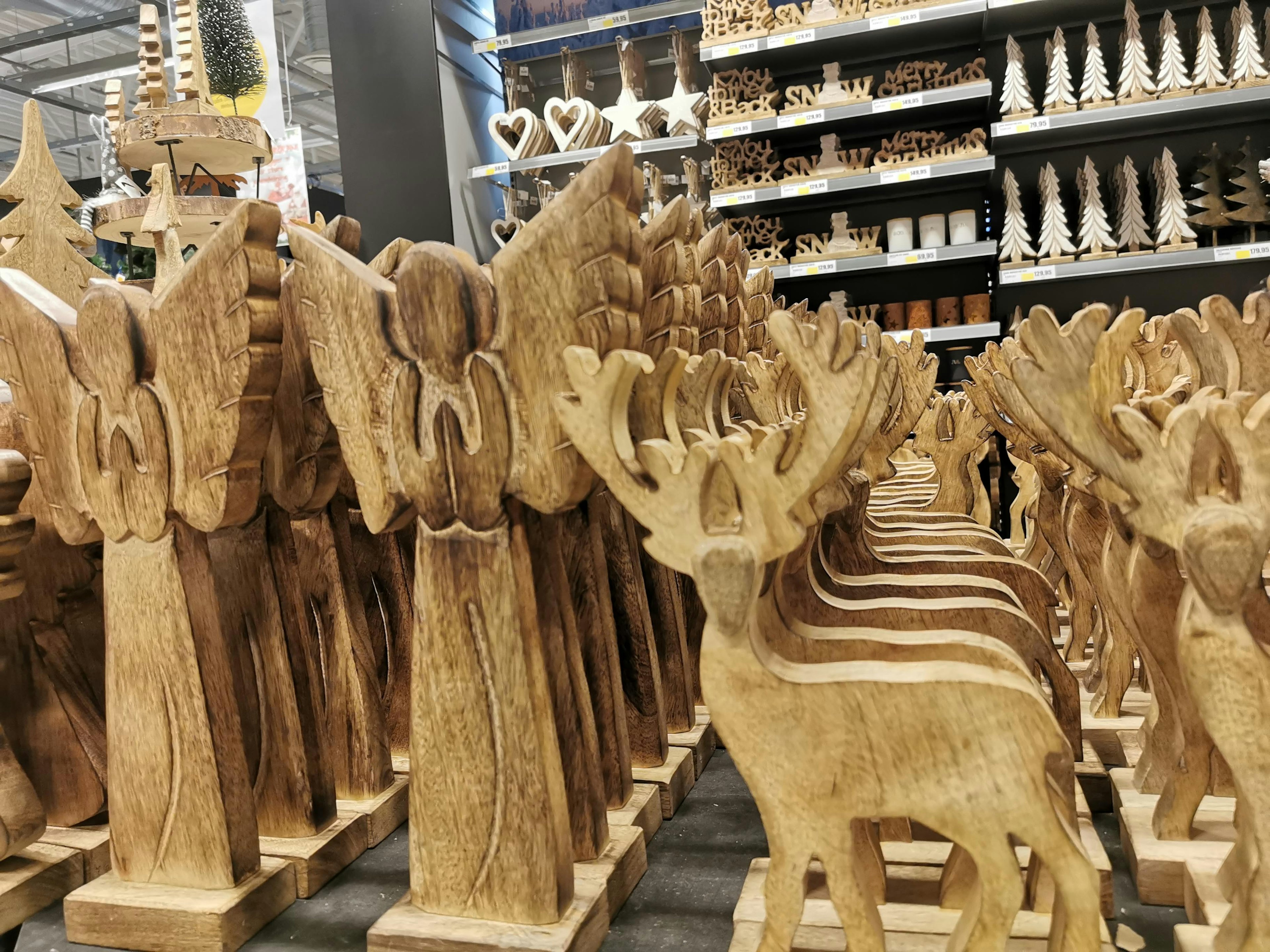 Wooden angel and deer decorations displayed in a store