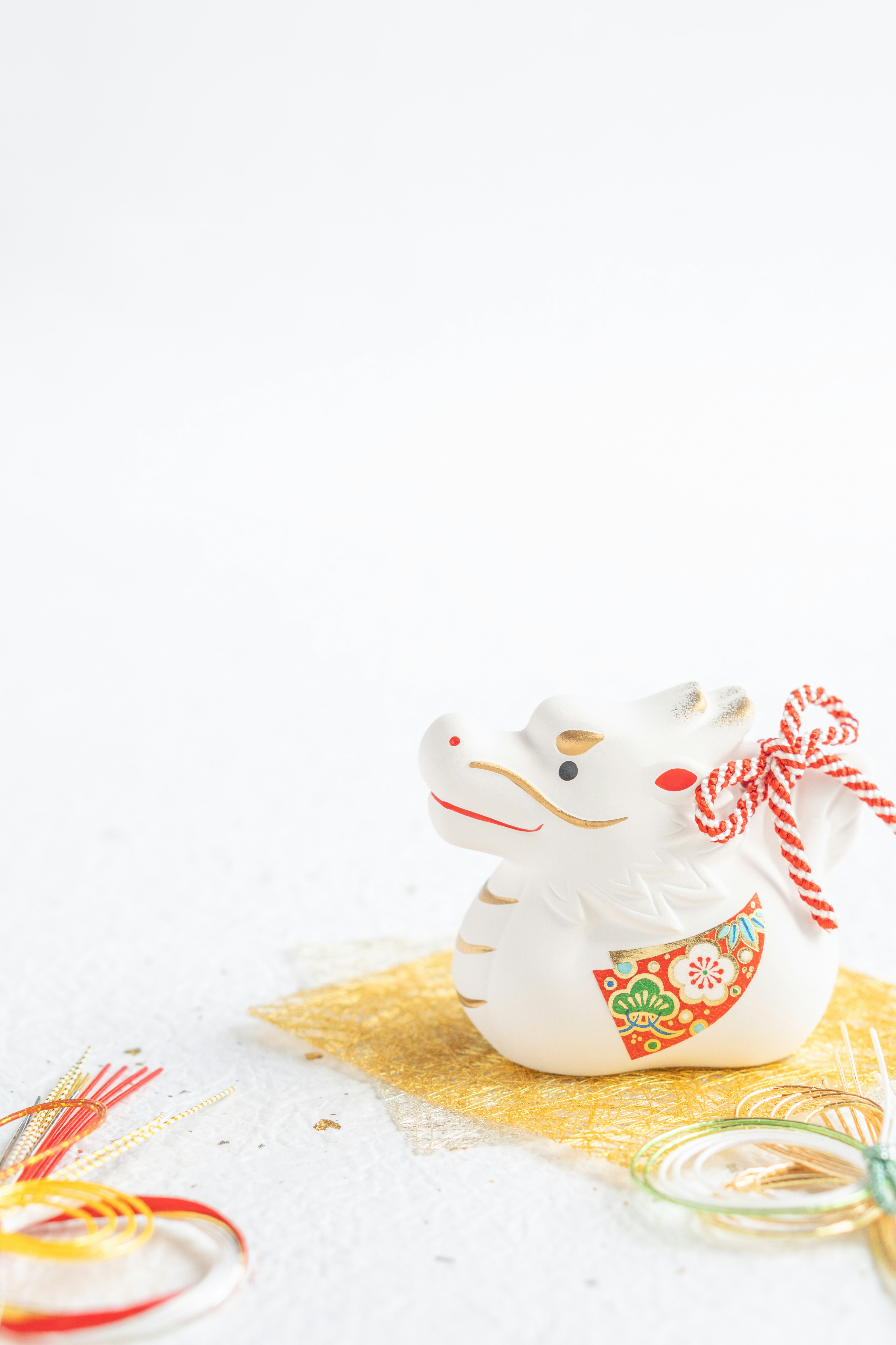 White ceramic zodiac ox figurine with red ribbon and floral pattern