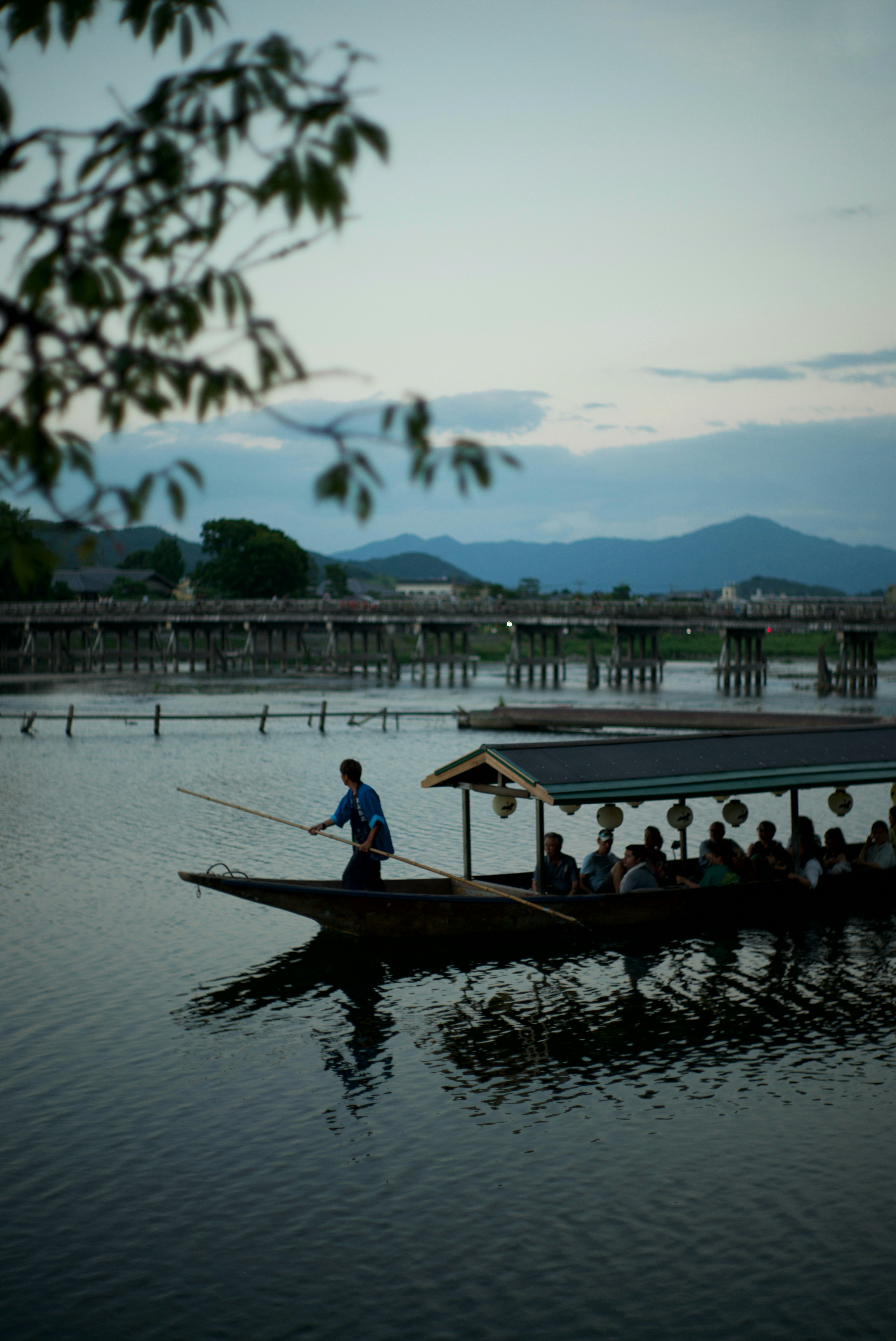 A fisherman casting a line from a small boat on a tranquil lake