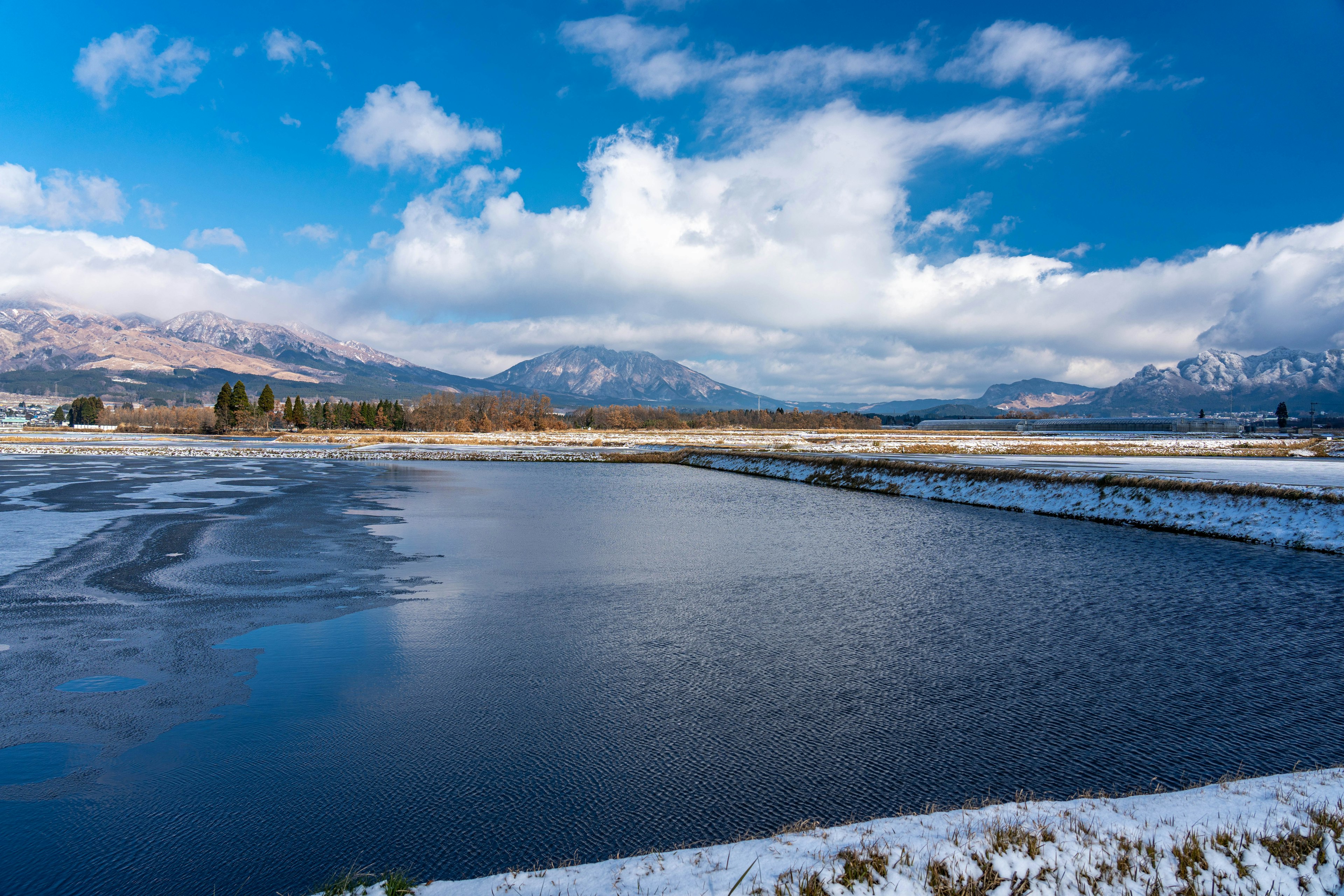 Panoramablick auf eine verschneite Landschaft mit blauem Himmel und Bergen