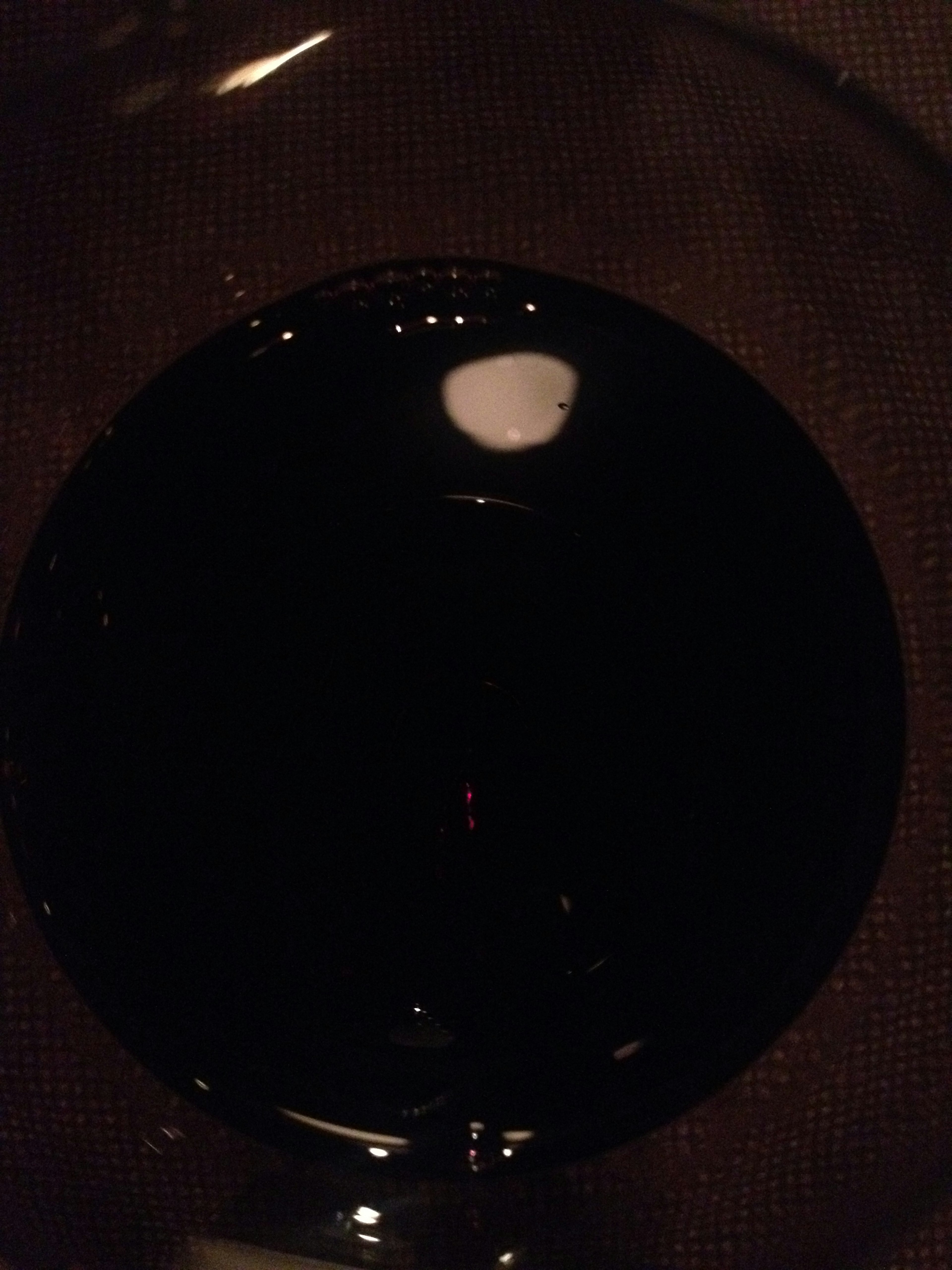 Top view of a glass containing black liquid with visible reflections