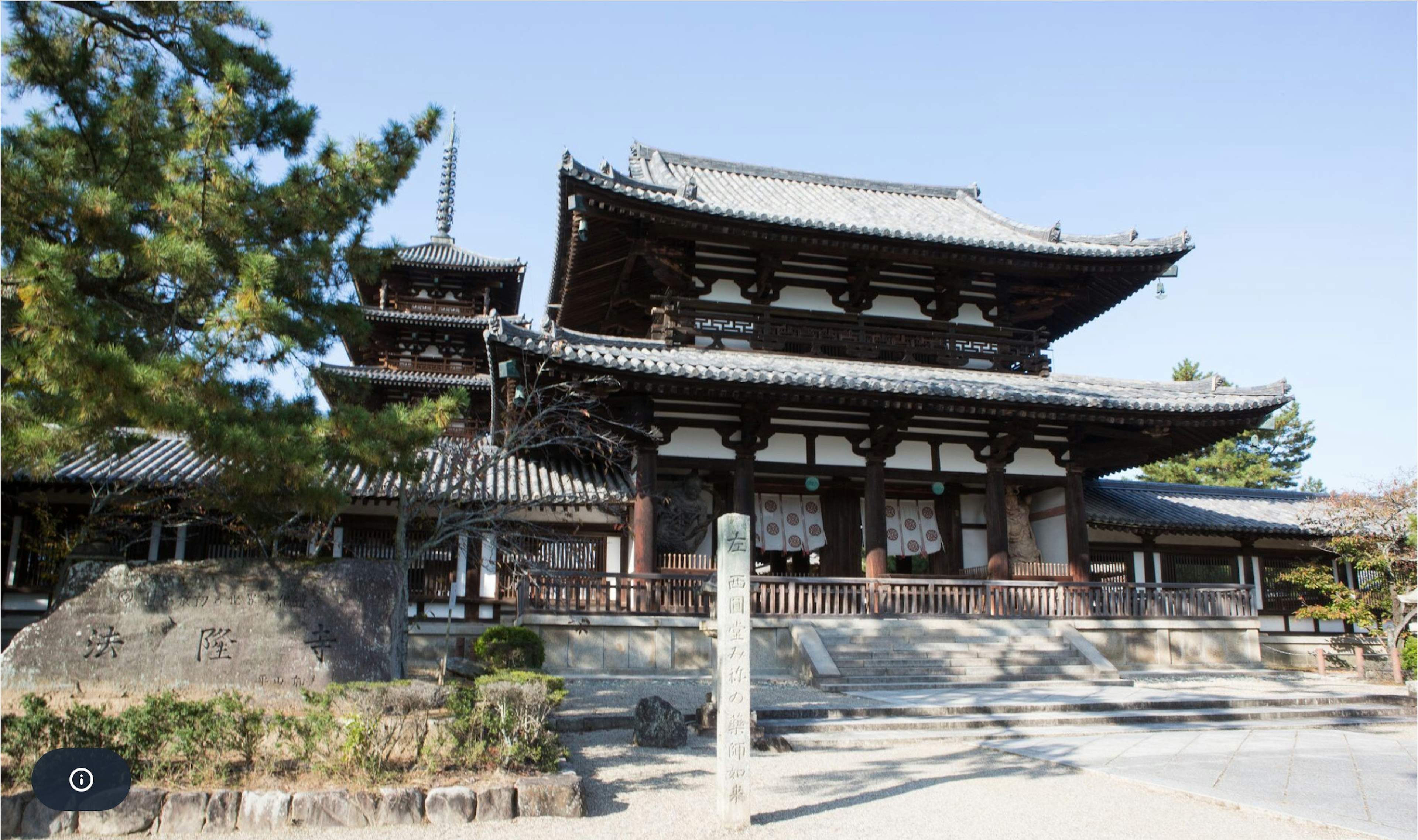 伝統的な日本の寺院建築が見える風景で、木造の構造と美しい屋根が特徴的