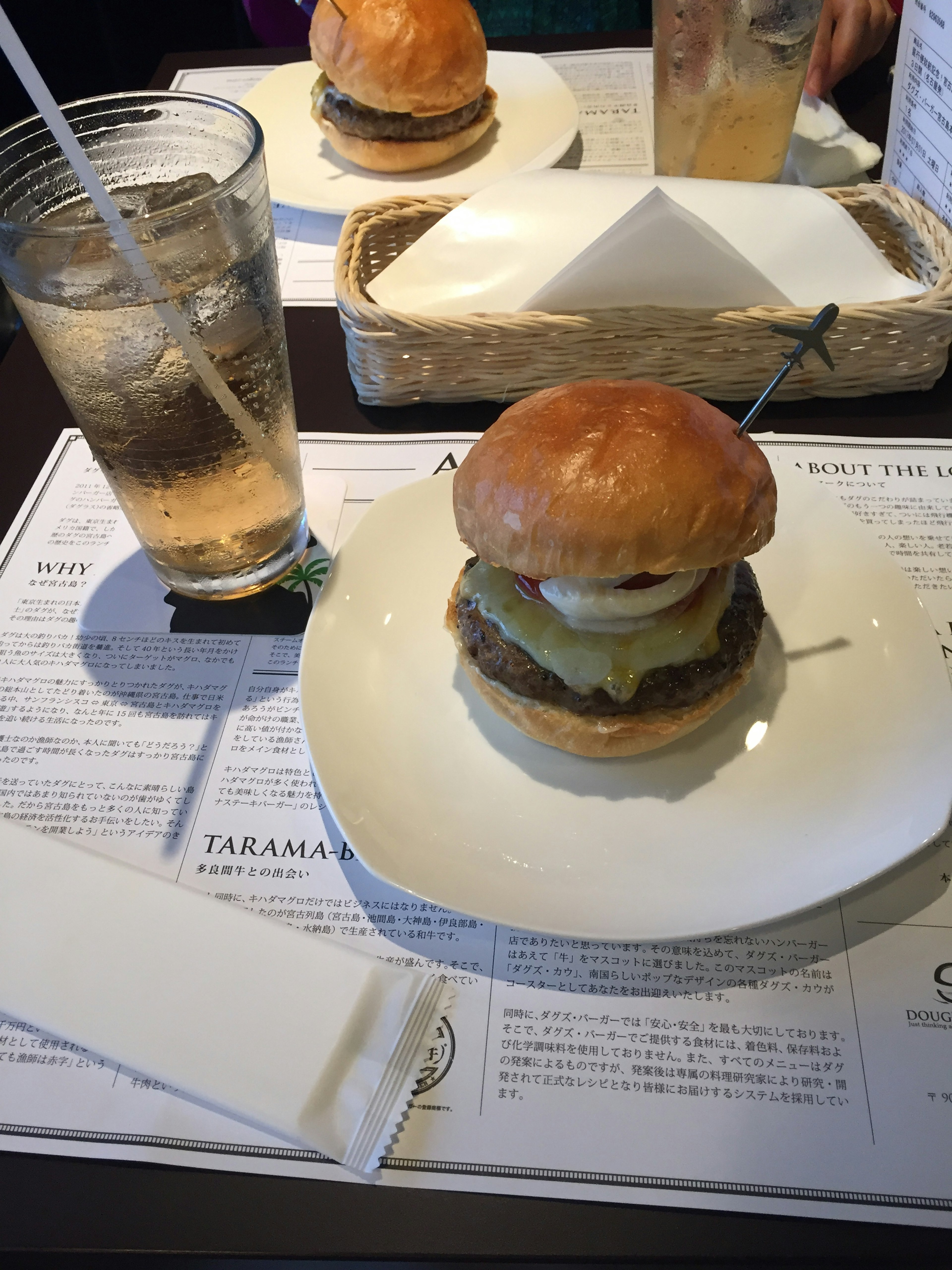 A close-up of a burger on a plate with a drink beside it